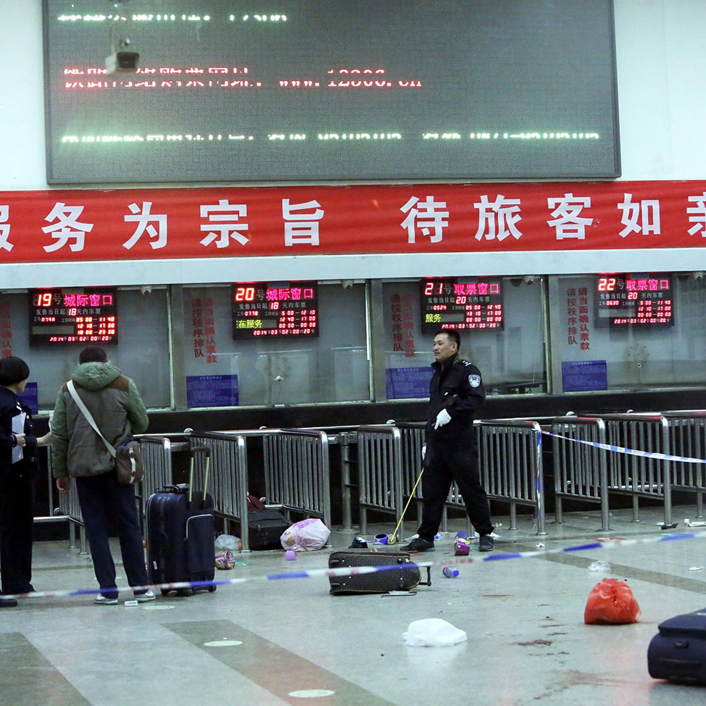 Chinese police investigators inspect the scene of an attack at the railway station in Kunming, southwest China's Yunnan province, on March 2, 2014.