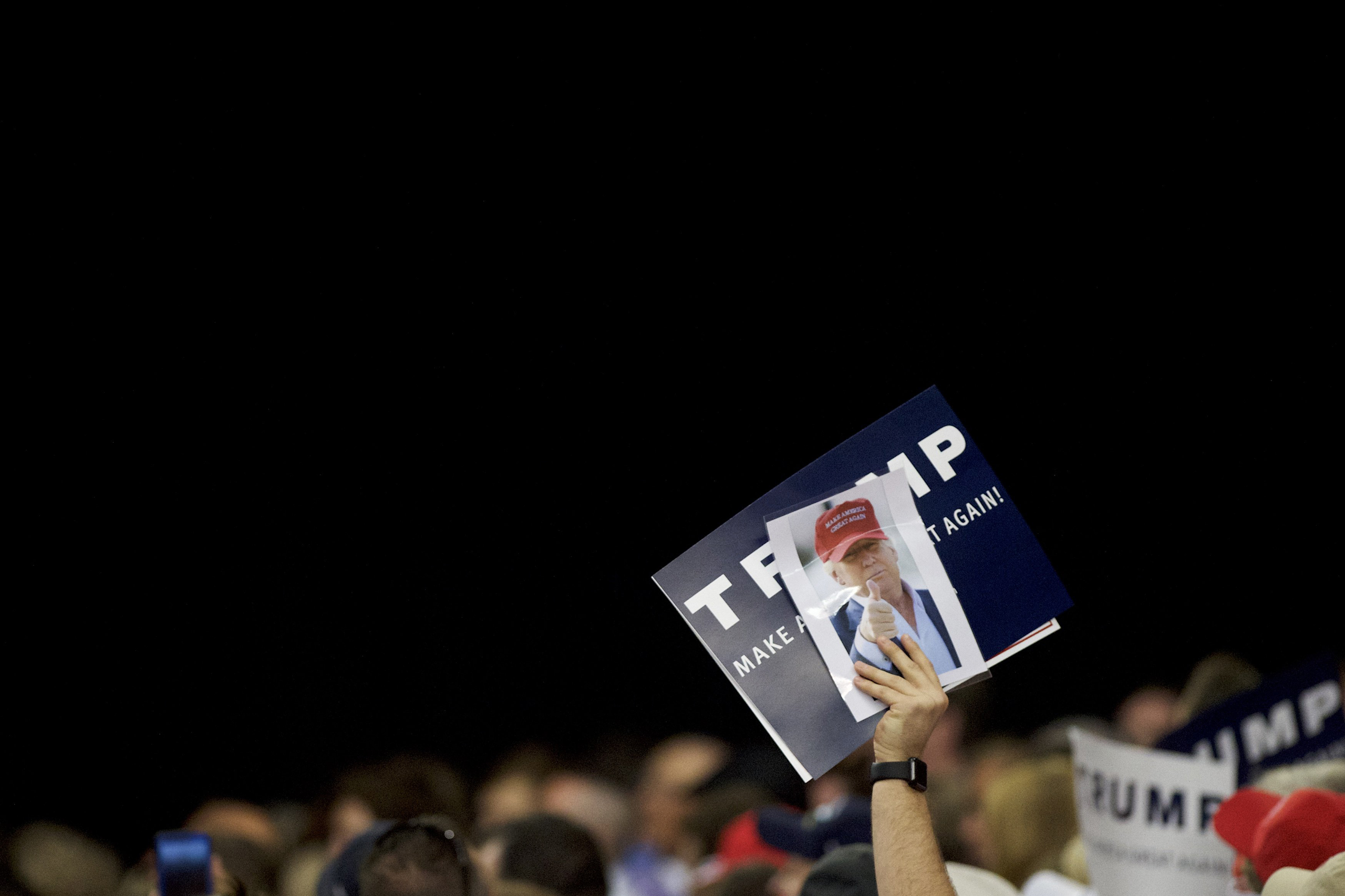 HARRISBURG, PA - APRIL 21: A Donald Trump supporter holds a campaign sign and photograph of the candidate during a rally at the Pennsylvania Farm Show Complex &amp; Expo Center on April 21, 2016 in Harrisburg, Pennsylvania. The Pennsylvania Primary takes