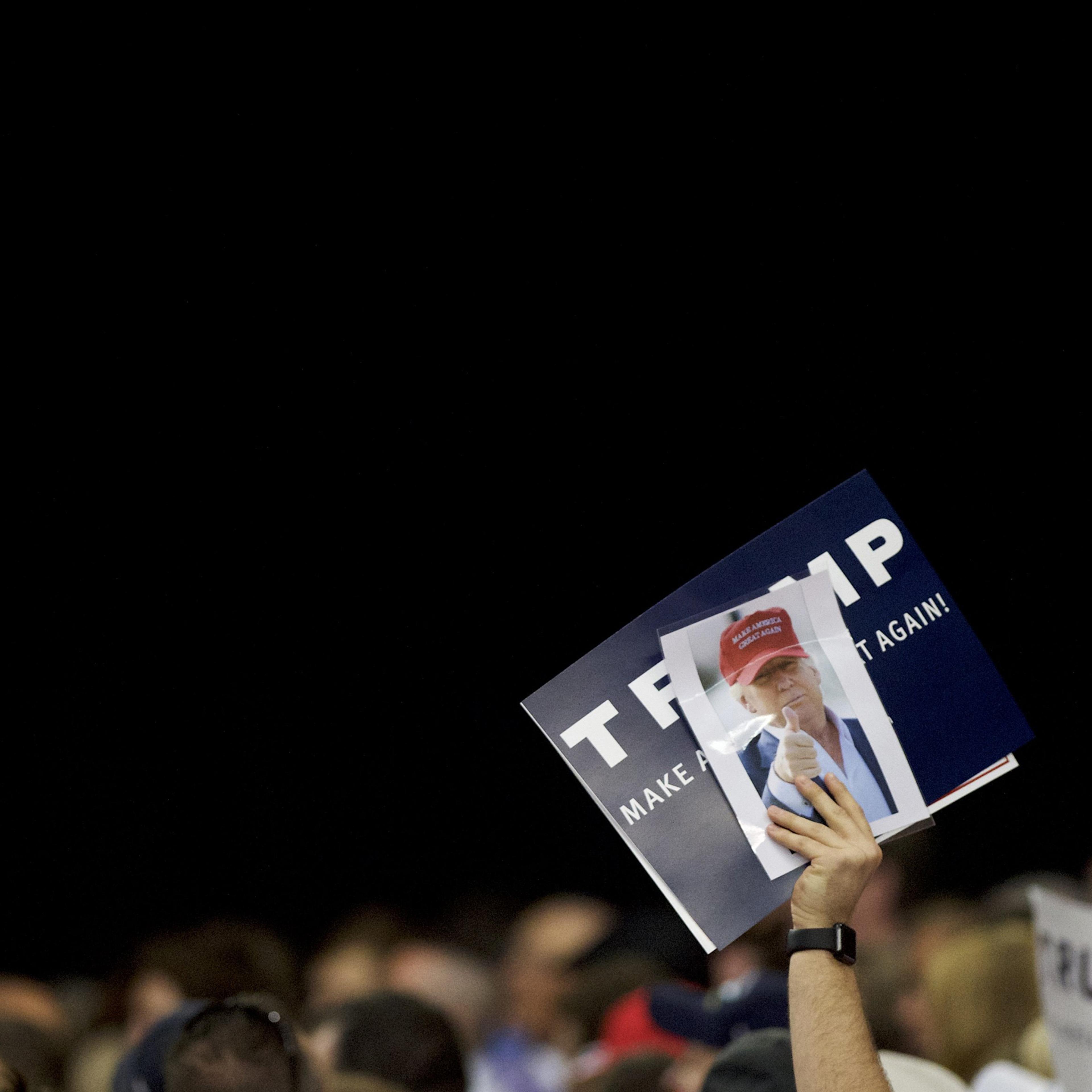 HARRISBURG, PA - APRIL 21: A Donald Trump supporter holds a campaign sign and photograph of the candidate during a rally at the Pennsylvania Farm Show Complex & Expo Center on April 21, 2016 in Harrisburg, Pennsylvania. The Pennsylvania Primary takes