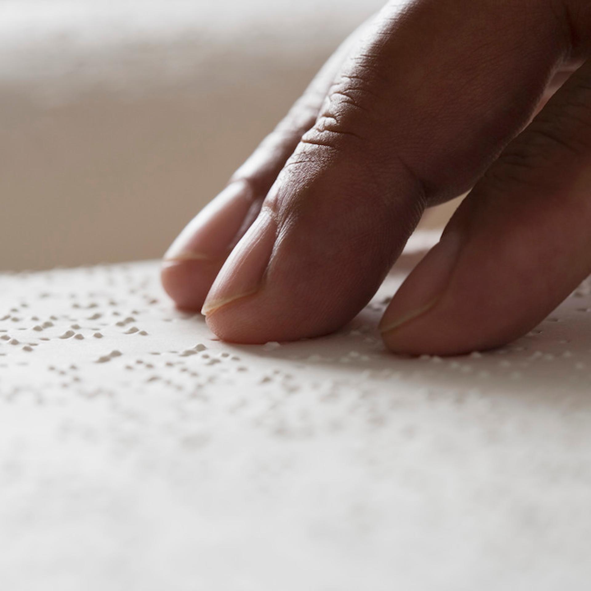 Close up of hand reading Braille