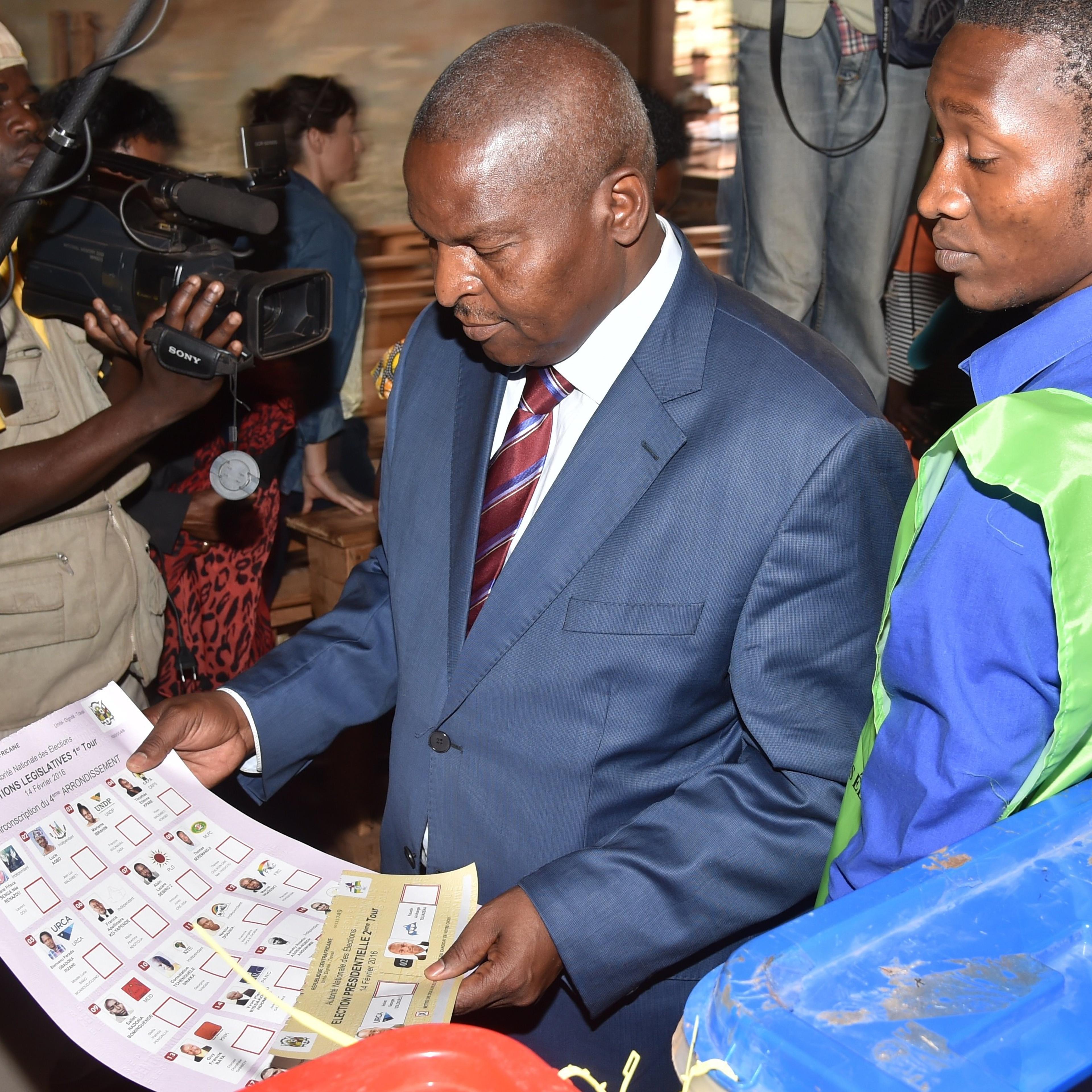 Central African Republic second round presidential candidate Faustin Archange Touadera (C) looks at a ballot before voting for delayed legislative elections and a presidential run-off, at a polling station in Bangui, on Feb. 14, 2016.