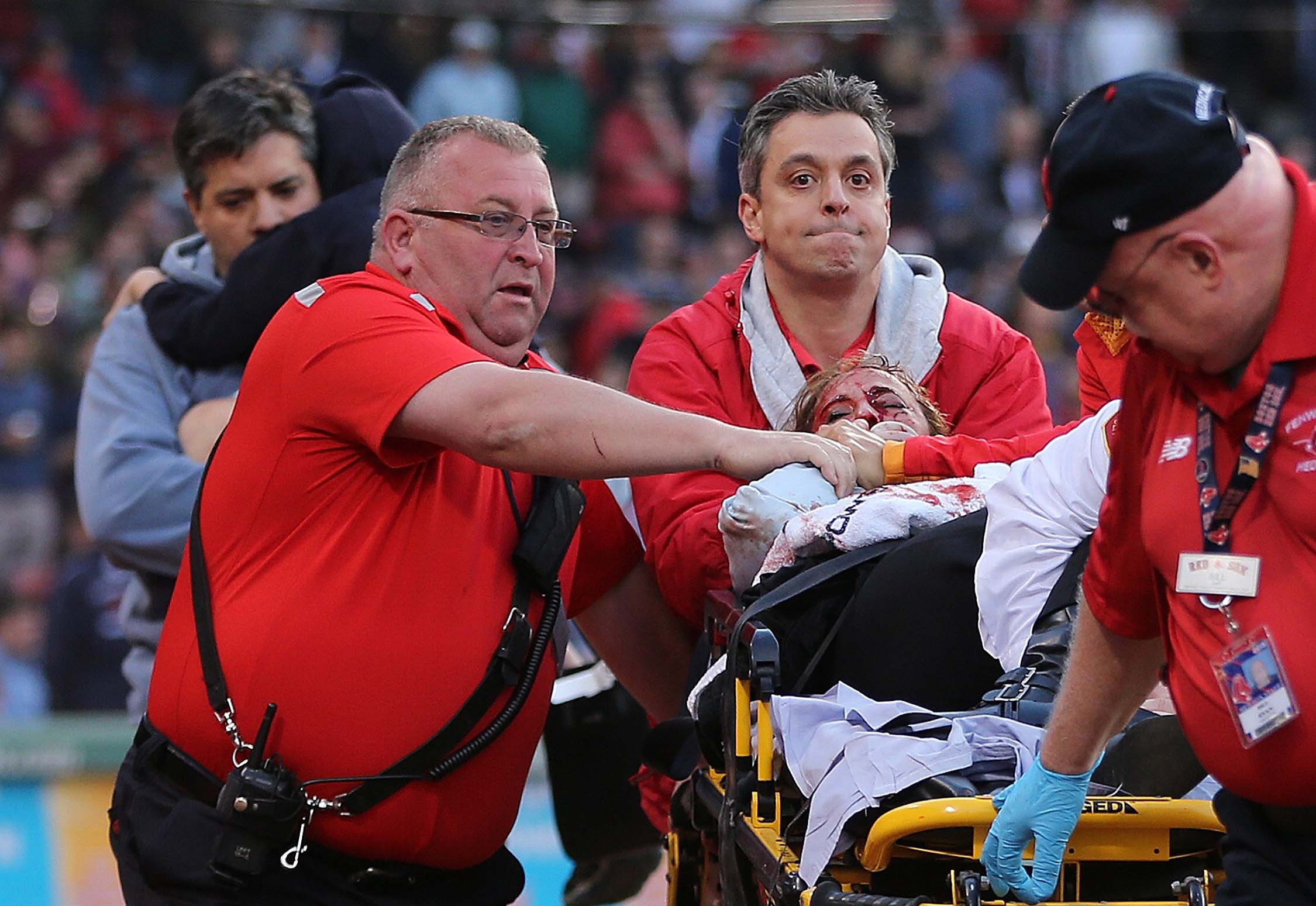 Medical staff attends to a woman who was hit by a broken bat during a game between the Boston Red Sox and the Oakland Athletics at Fenway Park on Friday, June 5, in Boston.