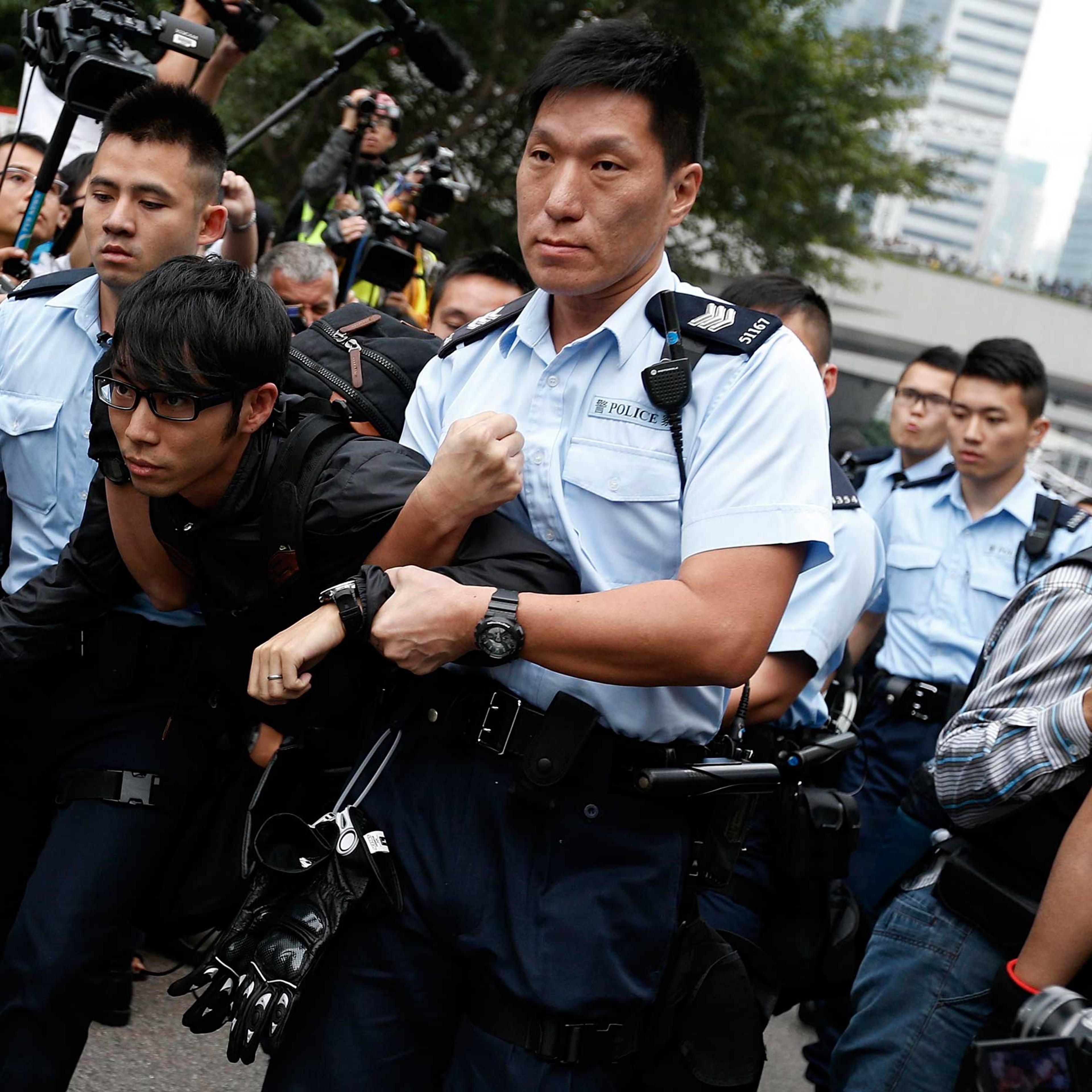 A demonstrator is taken away by policemen, at an area previously blocked by pro-democracy supporters, outside the government headquarters in Hong Kong, Dec. 11, 2014.