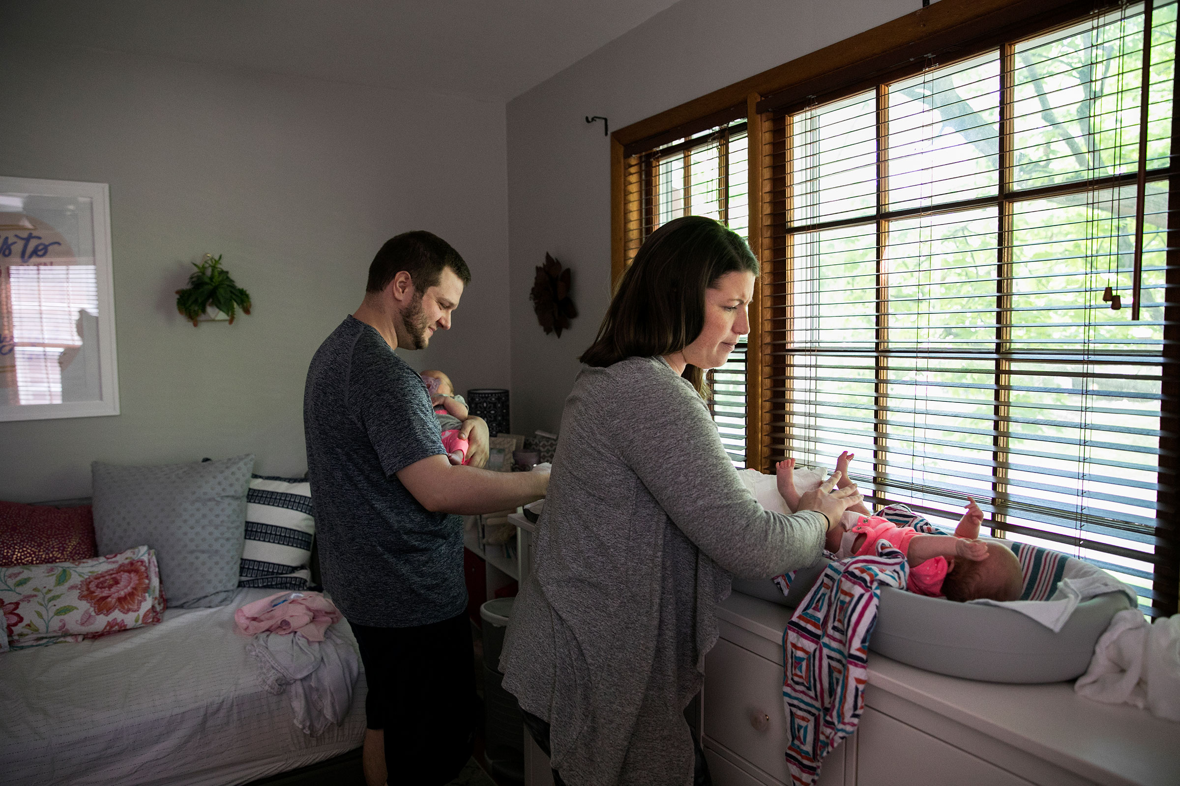 Morgan Lyles and her fiancé Chris Weien change the diapers of their 10-week old twin daughters Lena and Maura at home in Columbus, OH on May 11, 2019. Lyles had to return to work half way through her pregnancy when Weien was hospitalized to save her sick