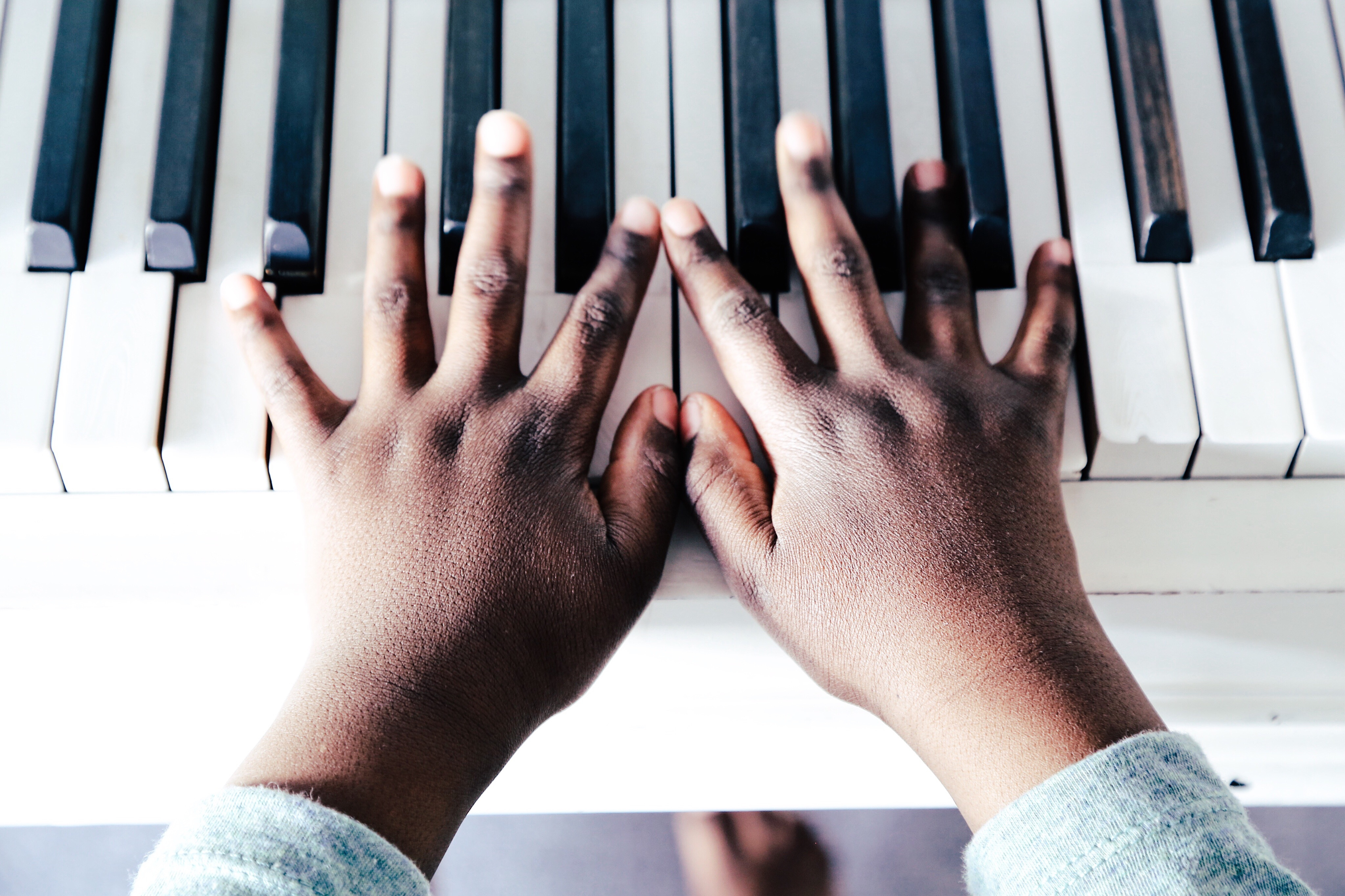 Cropped Hand Of Child Playing Piano