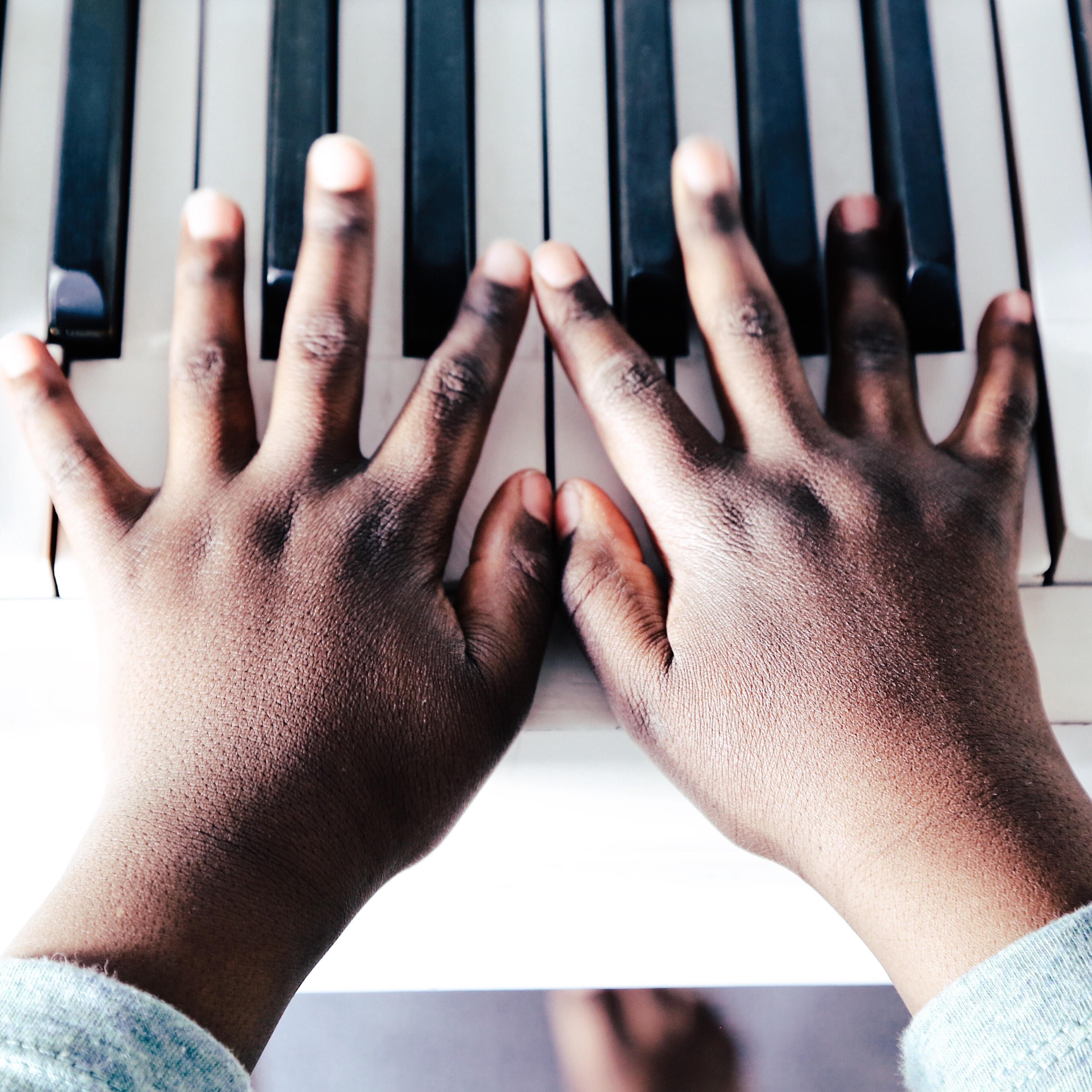 Cropped Hand Of Child Playing Piano