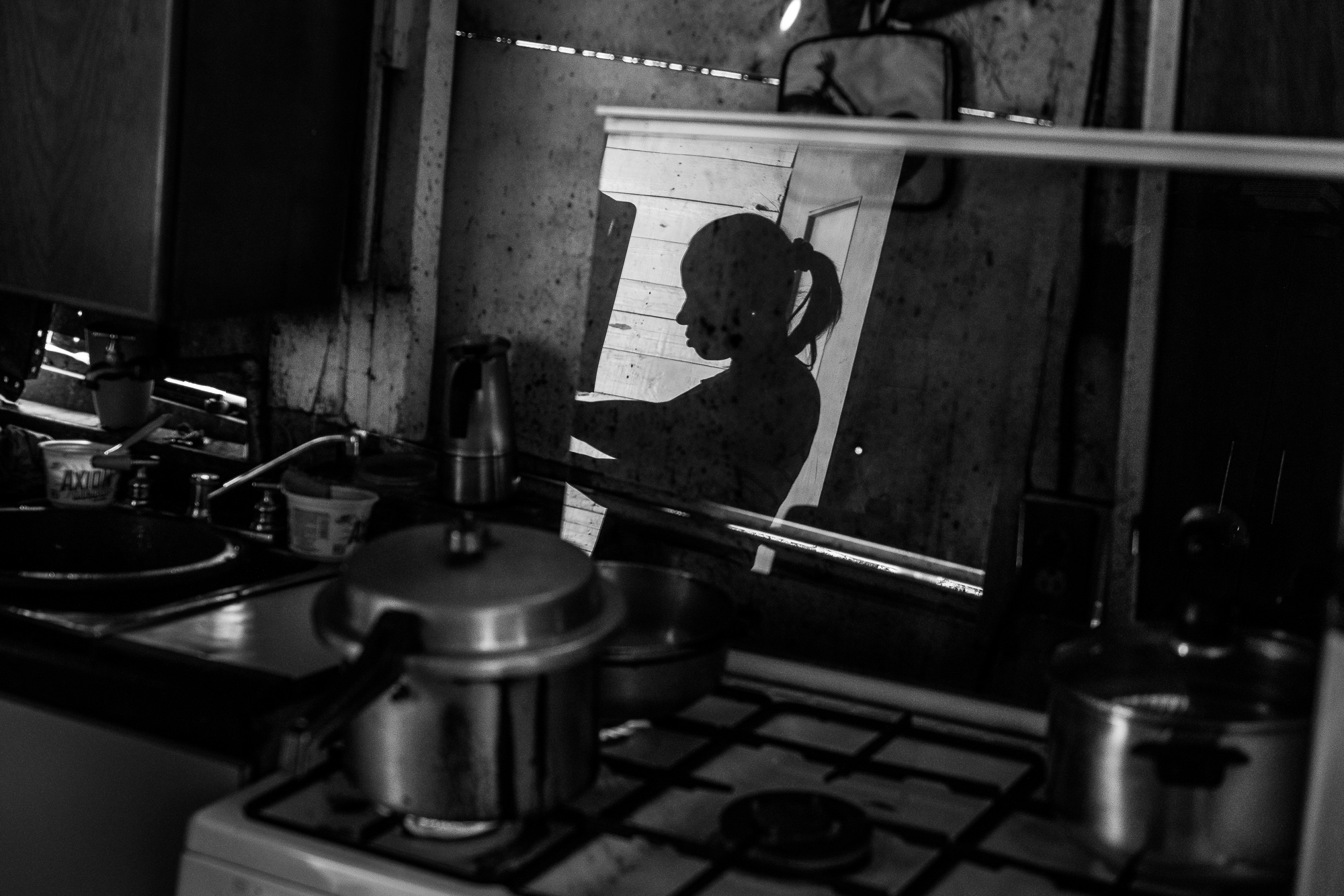 Mayra Castro, 37, prepares food at her makeshift home in Petare, Caracas. Her daughter died of hunger when she was only a year old.