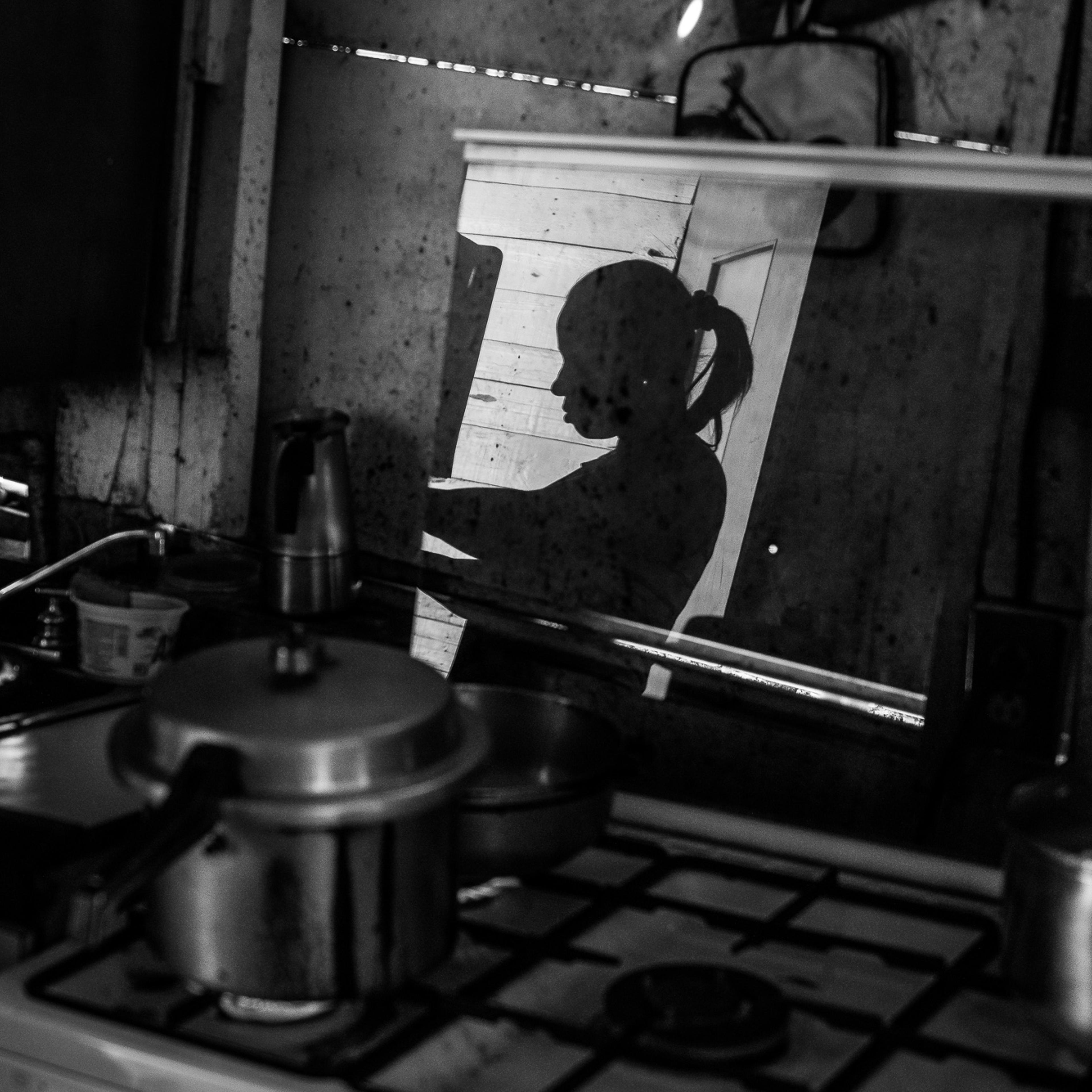 Mayra Castro, 37, prepares food at her makeshift home in Petare, Caracas. Her daughter died of hunger when she was only a year old.