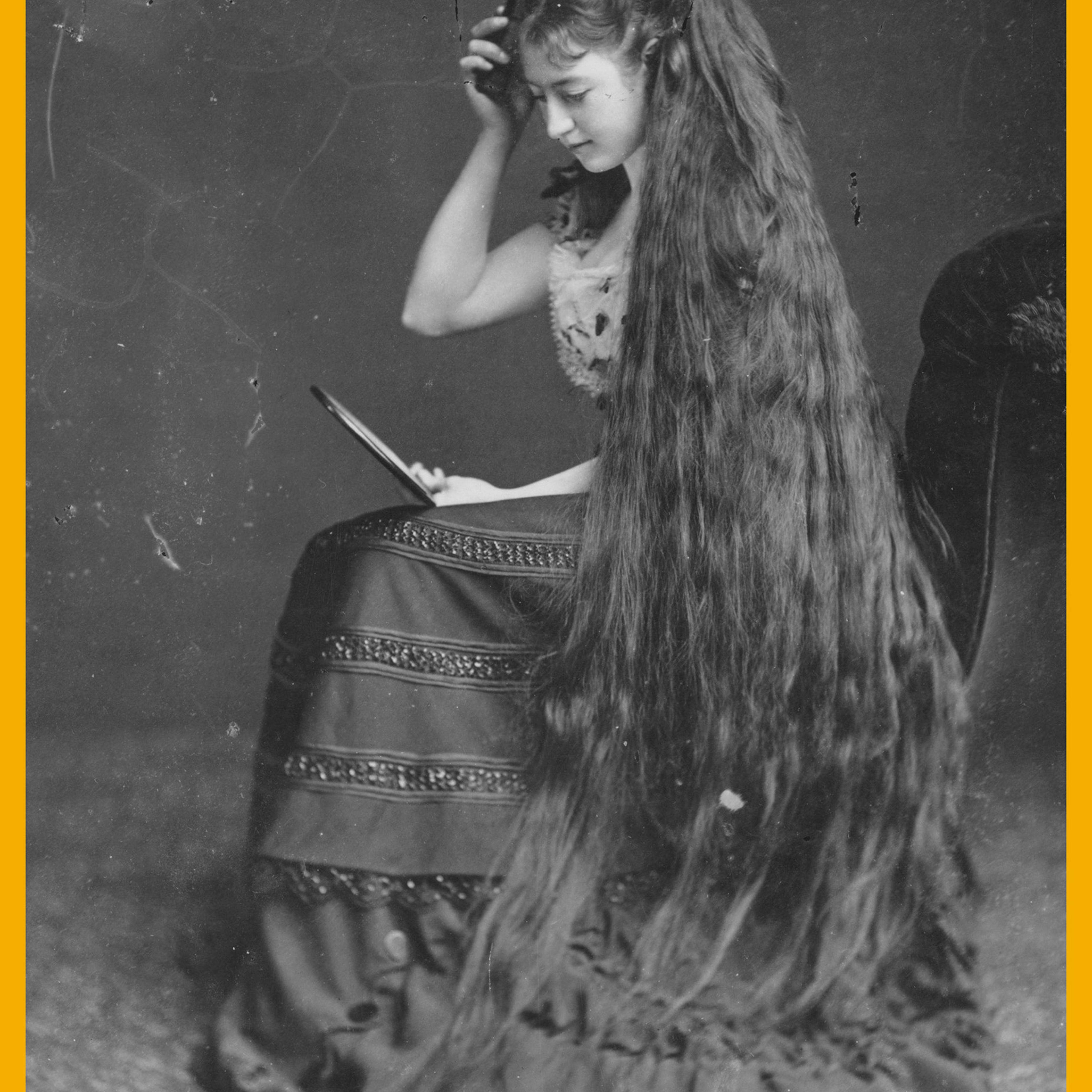 A woman combing her long hair circa 1885.