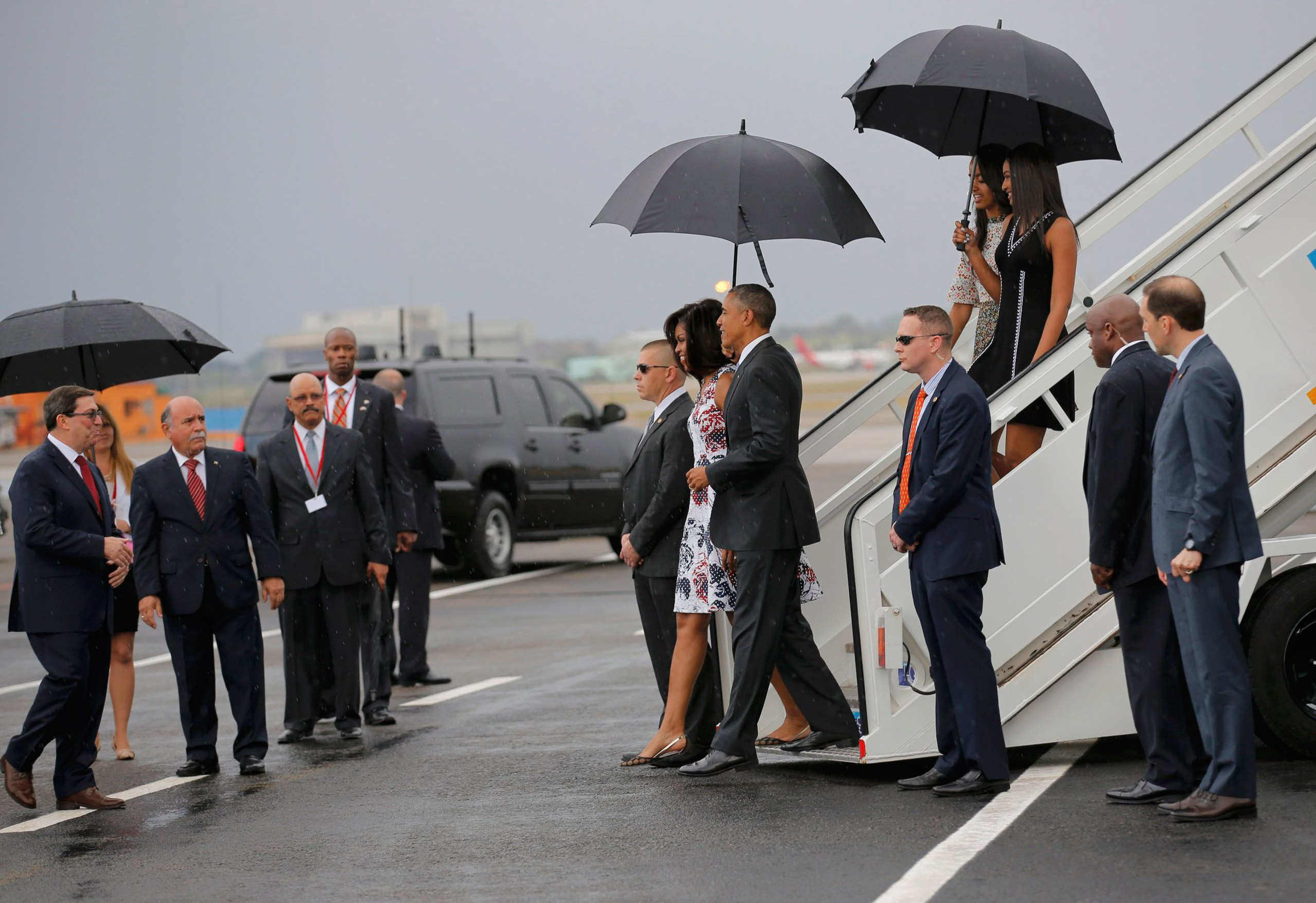 U.S. President Barack Obama and his wife Michelle approach Cuba's foreign minister Bruno Rodriguez (L) as they arrive at Havana's international airport for a three-day trip, in Havana March 20, 2016. REUTERS/Carlos Barria