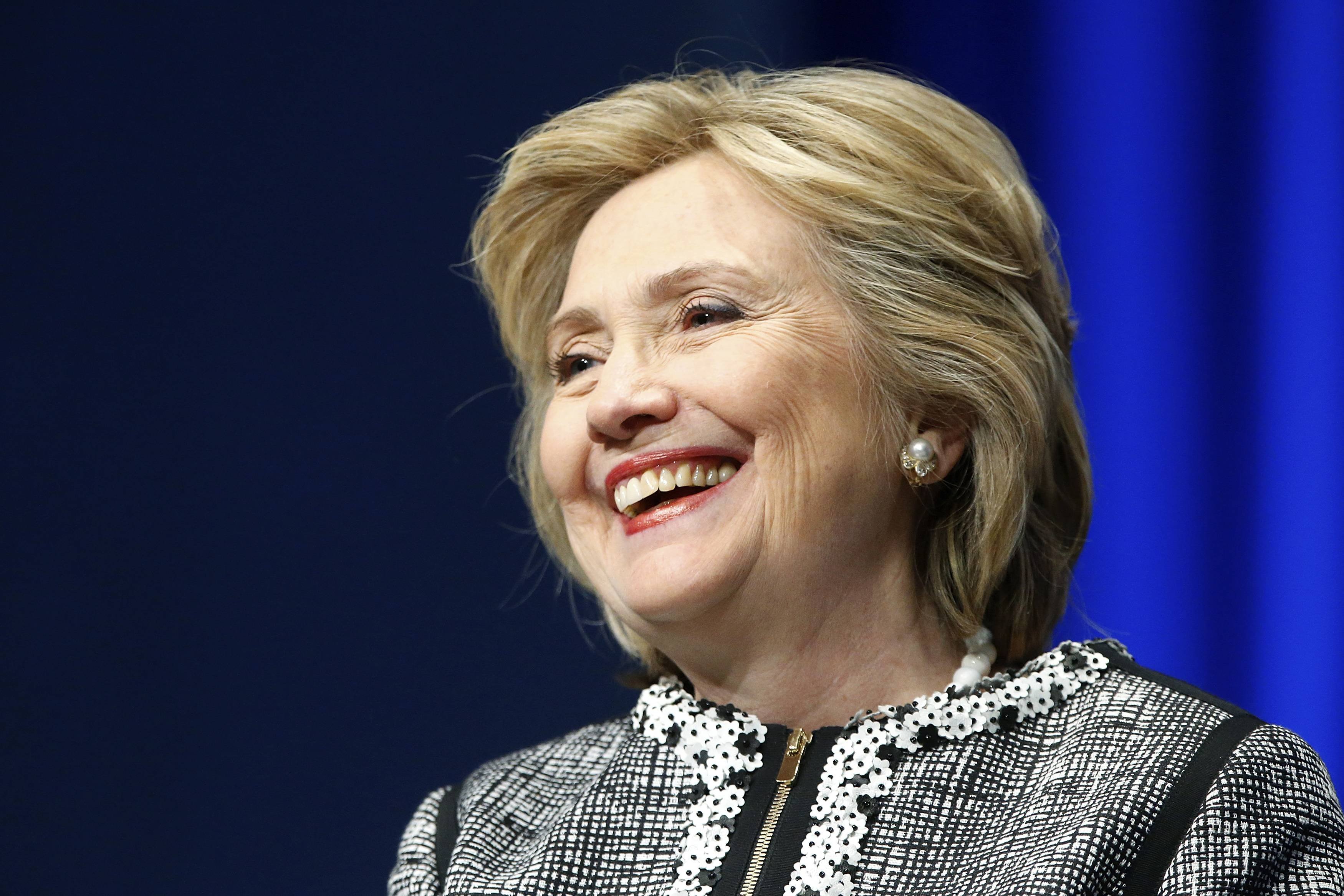 File photo of former U.S. Clinton smiling during a lengthy ovation for her at the start of an event on empowering woman and girls, at the World Bank in Washington