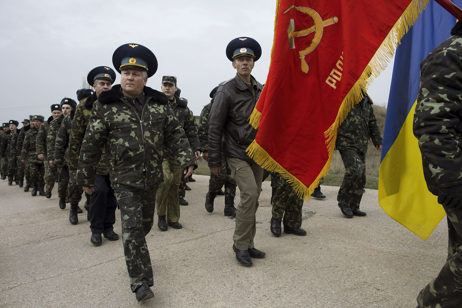 Unarmed Ukrainian soldiers, carrying a Soviet air-regiment banner, approach Russian positions on the perimeter of the contested Belbek air-force base in Crimea, Ukraine, on March 4, 2014.