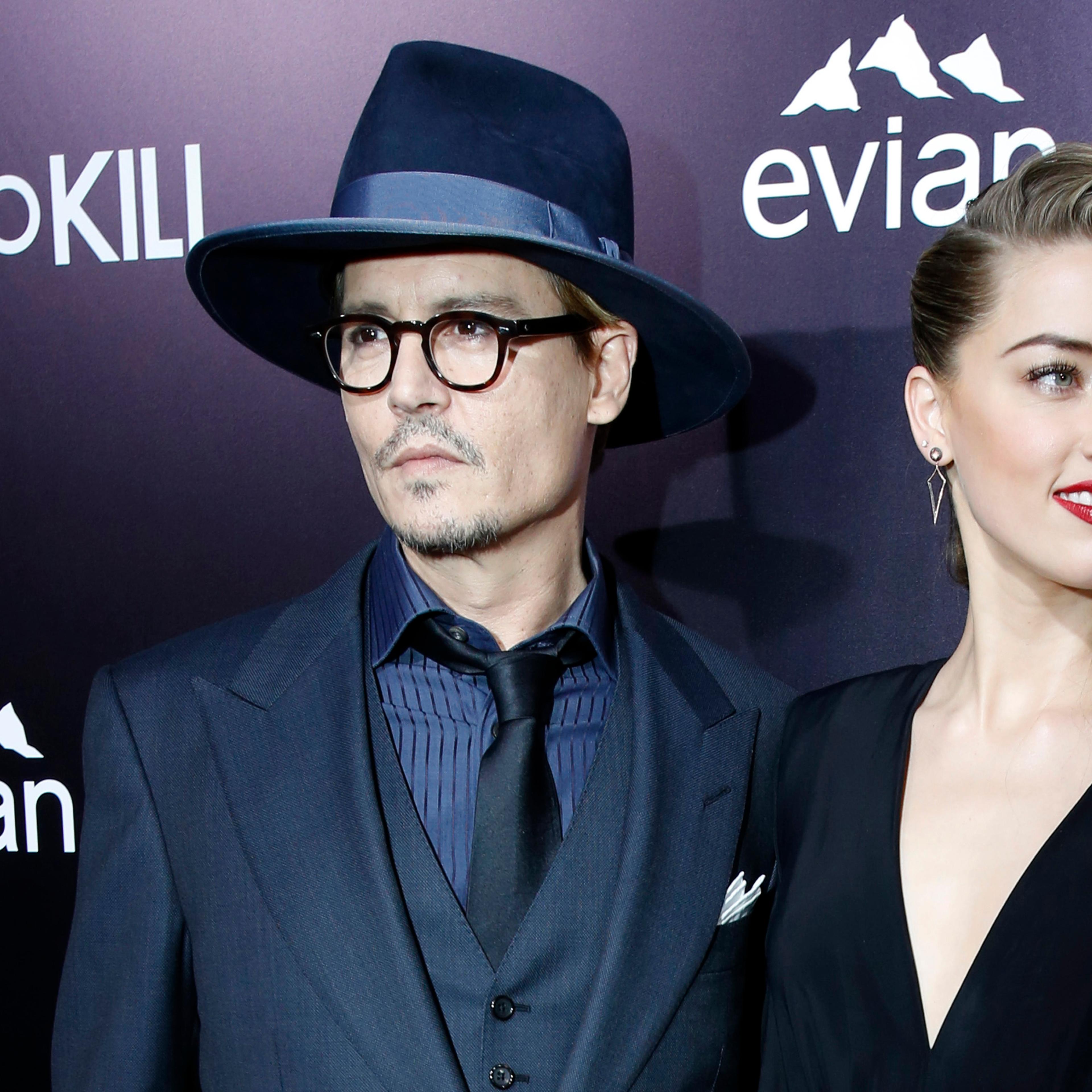Cast member Amber Heard and her fiance, actor Johnny Depp pose at the premiere of "3 Days to Kill" in Los Angeles
