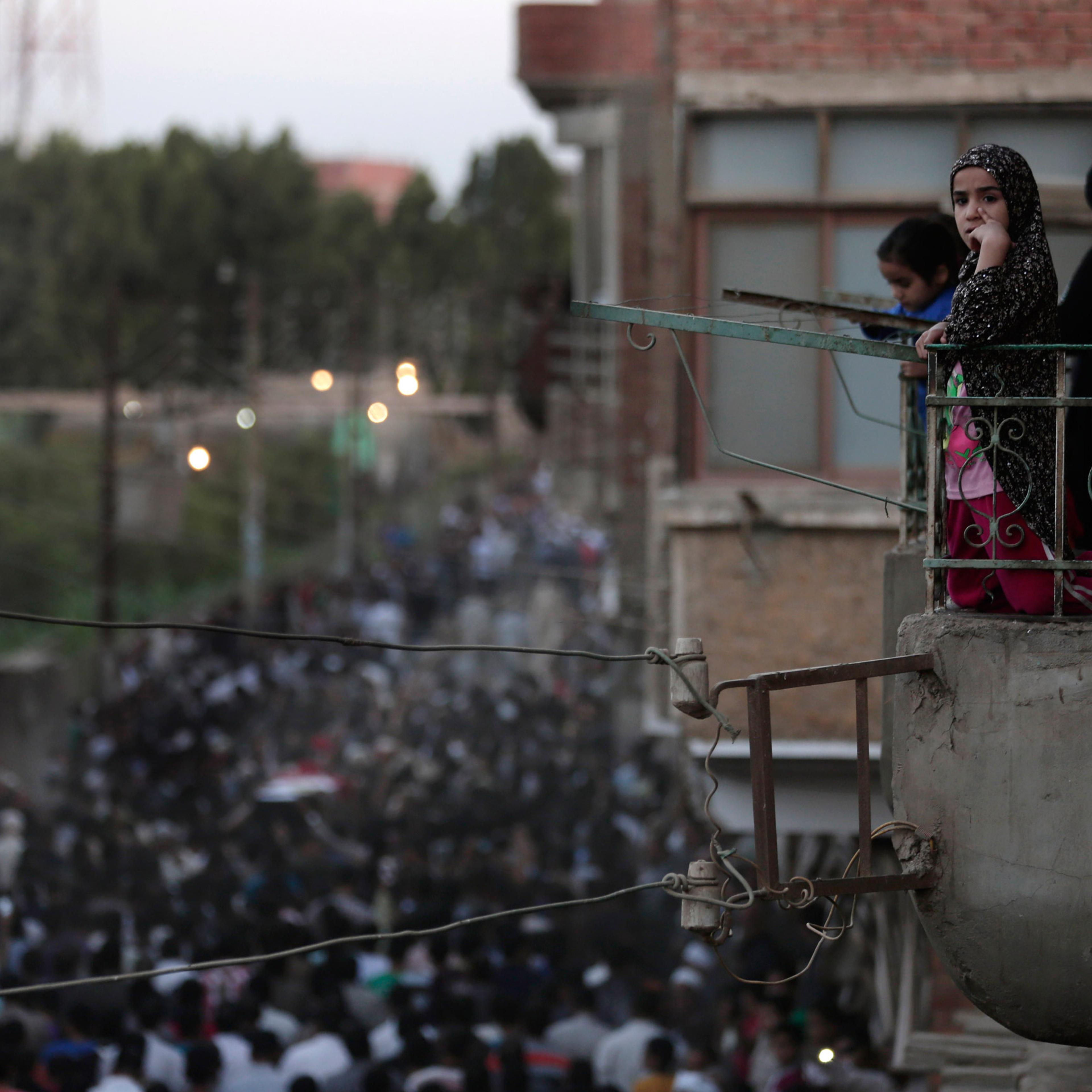 Egyptians mourn as they watch from their balcony during the funeral procession of 1st Lt. Mohammed Adel Abdel Azeem, killed in Wednesday's attack by Islamic militants in the Sinai, at his home village Tant Al Jazeera in Qalubiyah, north of Cairo, Egypt,
