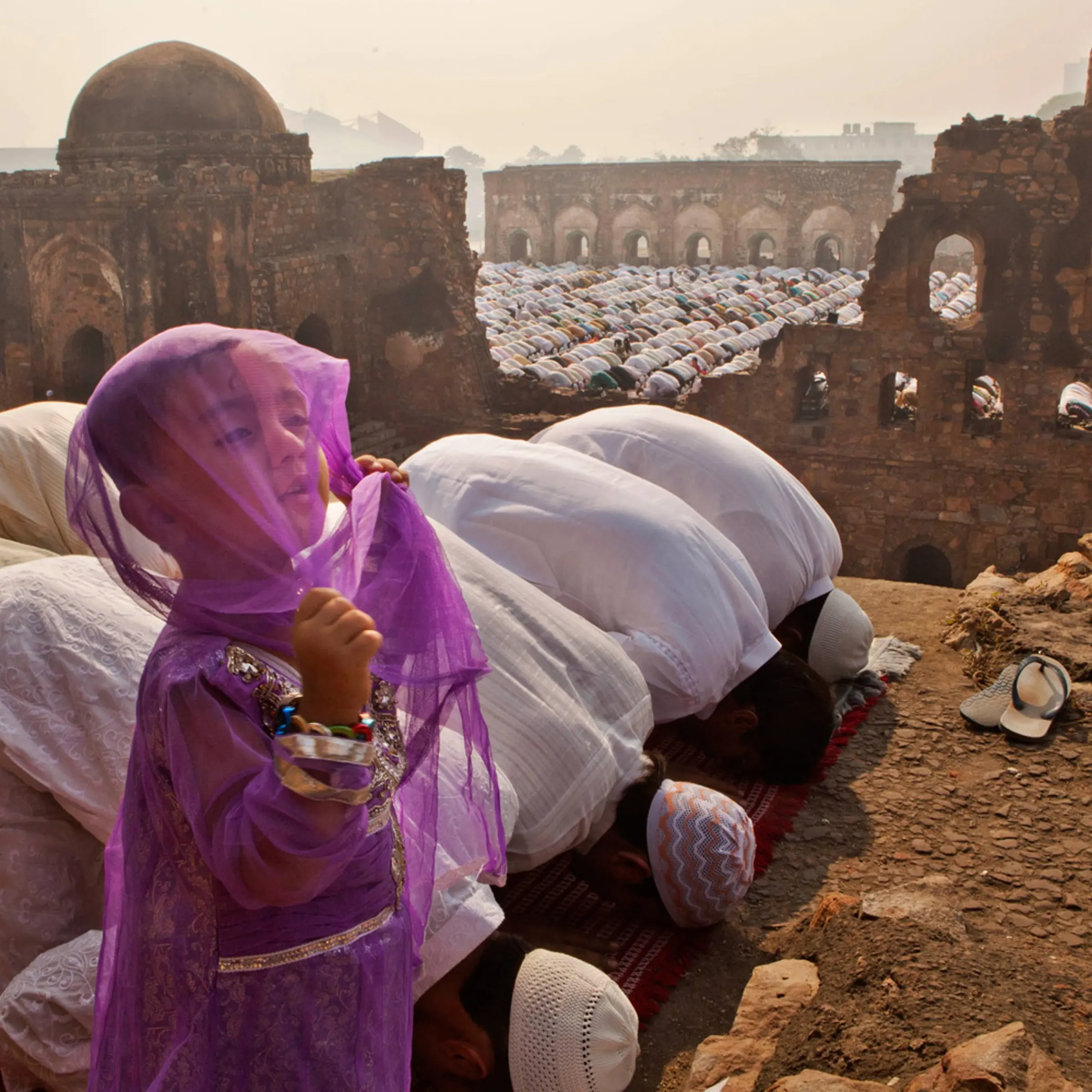 November 7, 2011. A young Indian Muslim girl stands while others pray in New Delhi during 'Id al Adha, the Festival of Sacrifice, which follows the end of the Hajj, the annual pilgrimage to Mecca.