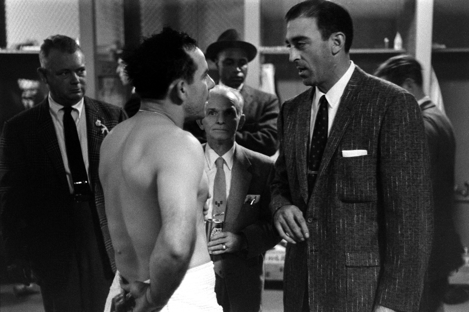 Yogi Berra (l.), who caught Don Larsen's Oct. 8, 1956, perfect game and the Dodgers' losing pitcher, Sal Maglie, chat afterward in the Yankee Stadium locker room. Between Berra and Maglie, clutching a can of beer, is the Yankees' long-time public relatio