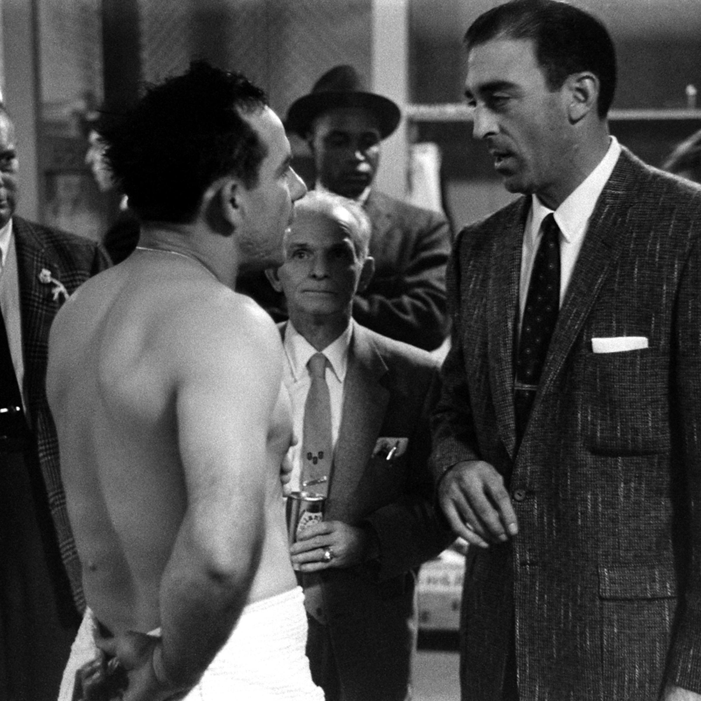 Yogi Berra (l.), who caught Don Larsen's Oct. 8, 1956, perfect game and the Dodgers' losing pitcher, Sal Maglie, chat afterward in the Yankee Stadium locker room. Between Berra and Maglie, clutching a can of beer, is the Yankees' long-time public relatio