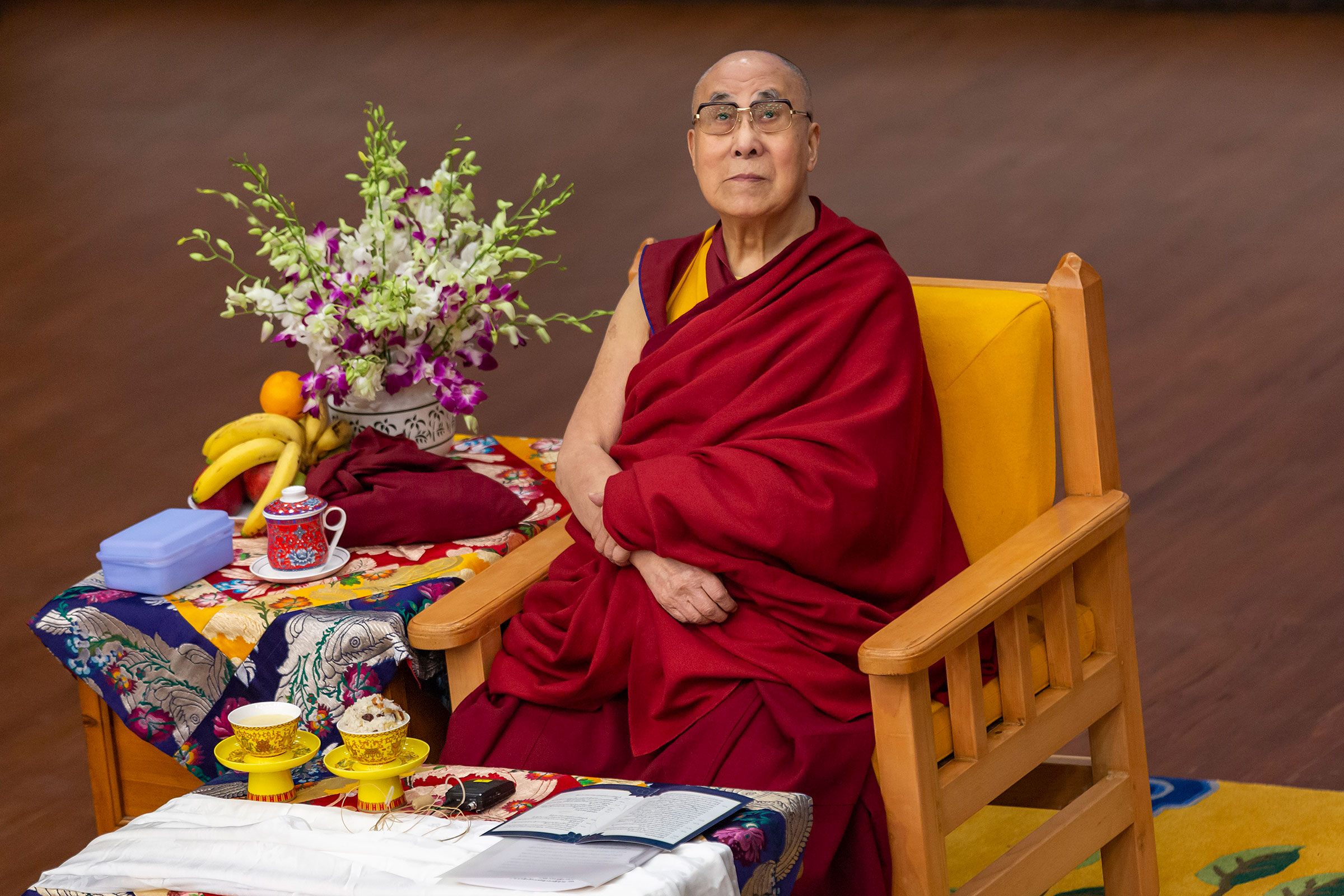 Tibetan spiritual leader the Dalai Lama looks on as he sits on his ceremonial chair