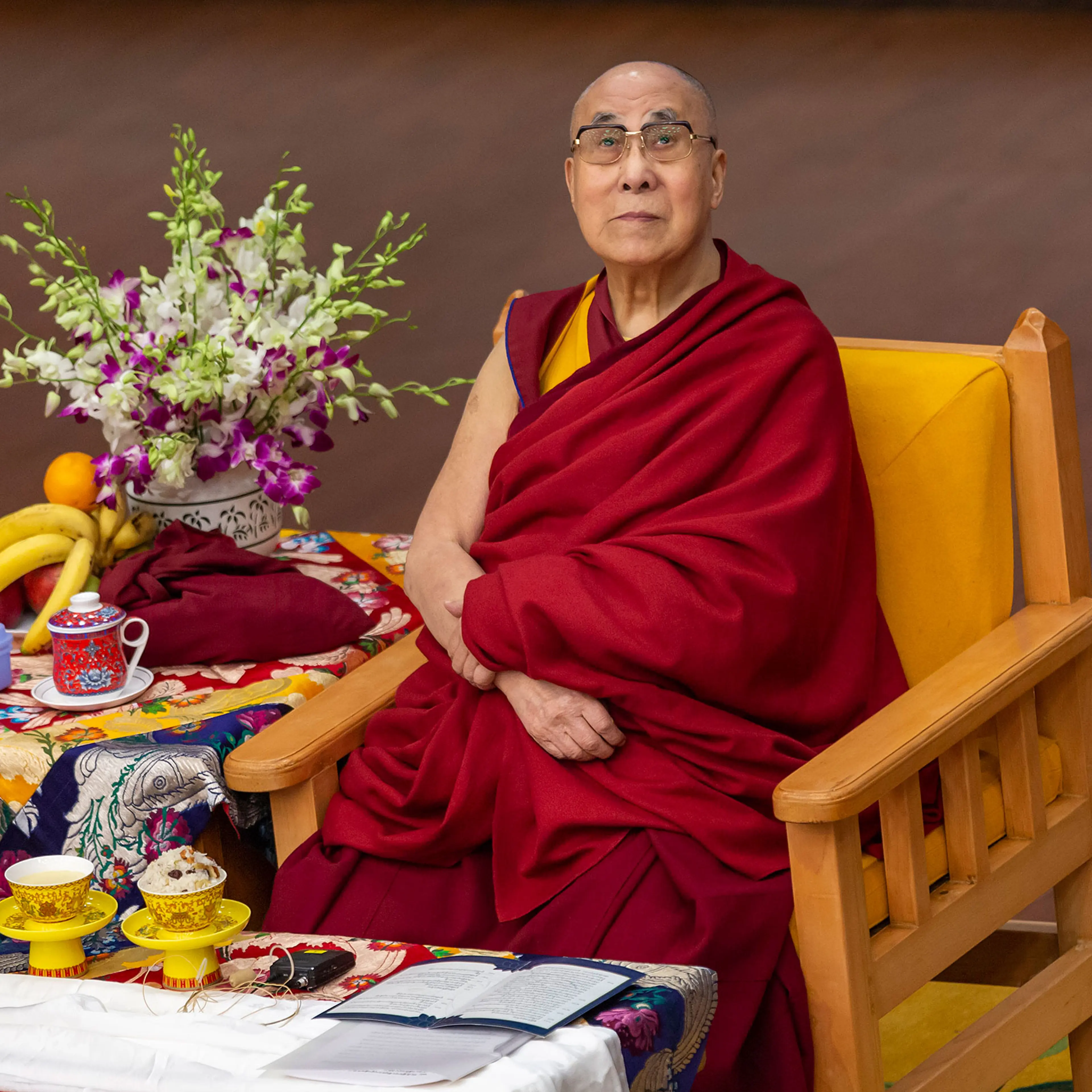 Tibetan spiritual leader the Dalai Lama looks on as he sits on his ceremonial chair