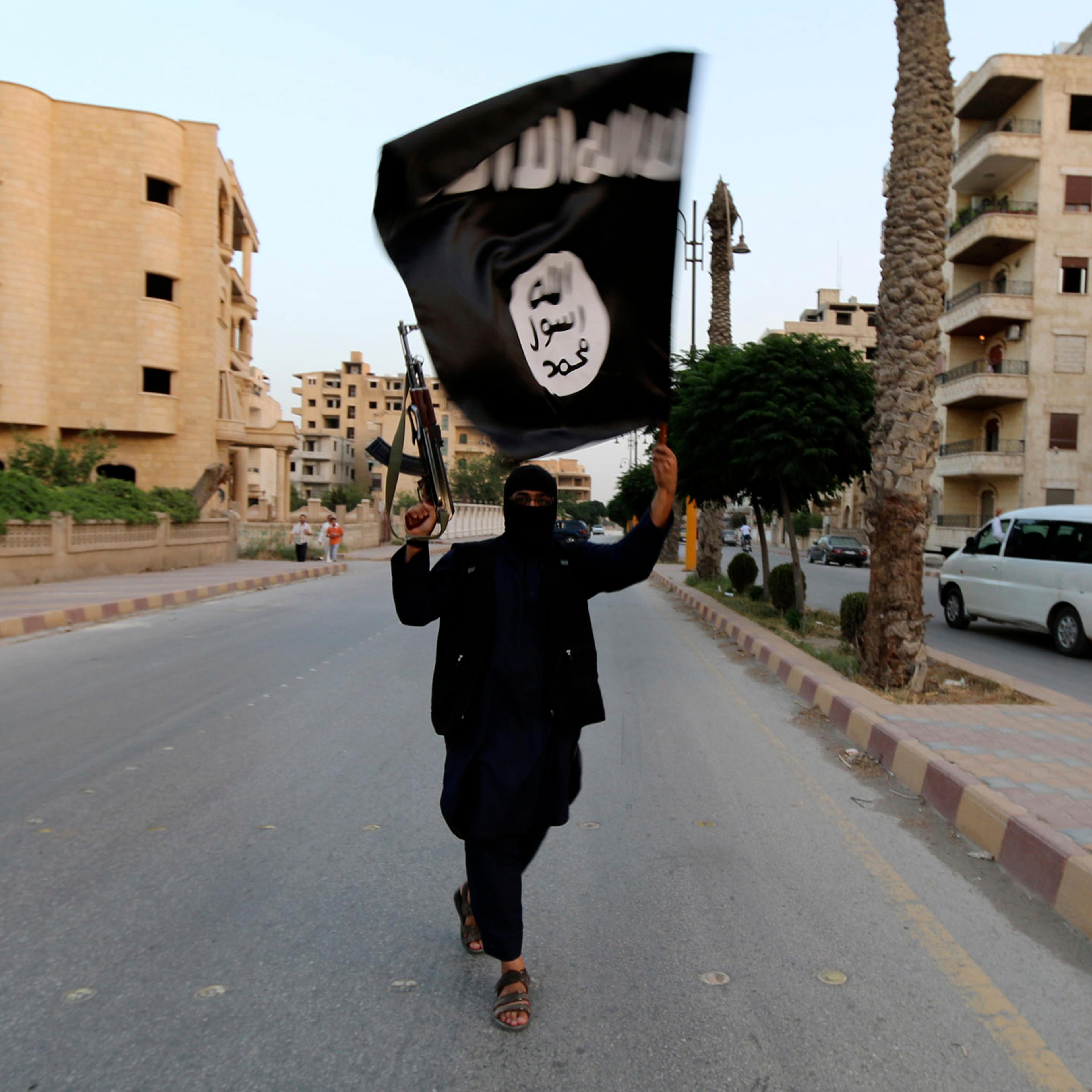 A member loyal to the ISIL waves an ISIL flag in Raqqa
