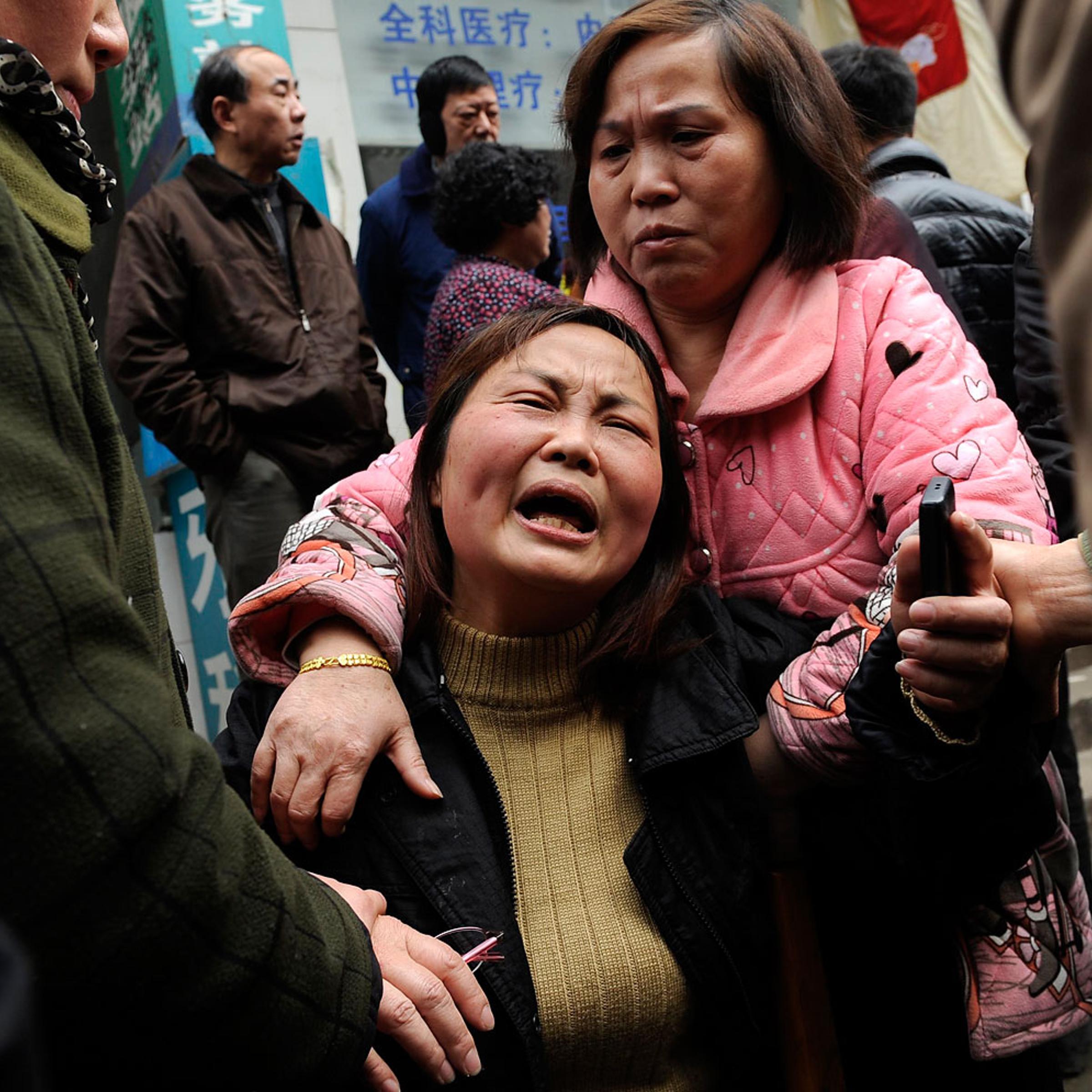 A woman cries after her parent was killed in a knifing incident in Changsha, Hunan province March 14, 2014.