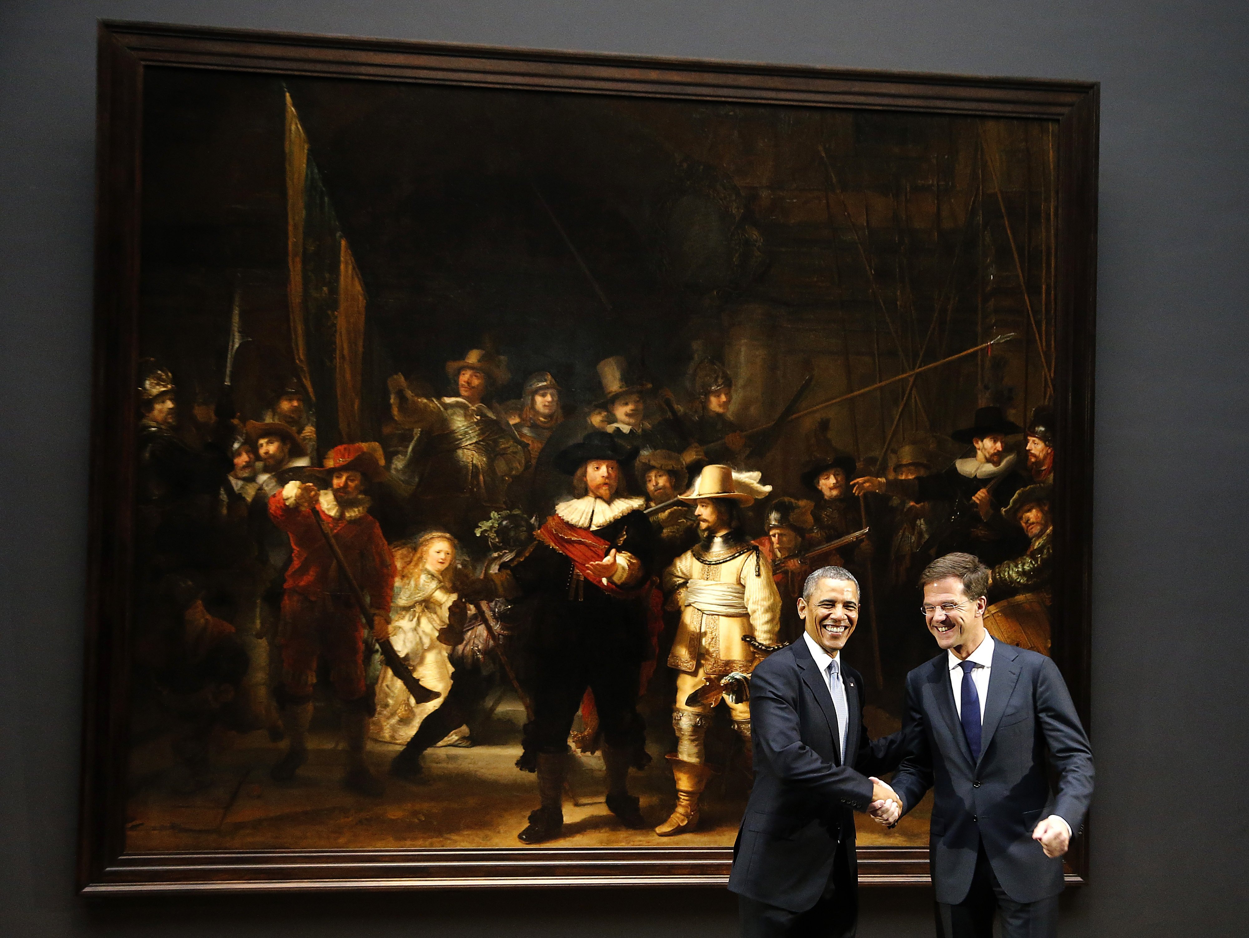 U.S. President Barack Obama, left, shakes hands with Dutch Prime Minister Mark Rutte, right, in front of Dutch master Rembrandt's The Night Watch painting during a visit to the Rijksmuseum in Amsterdam, Netherlands, Monday, March 24, 2014.