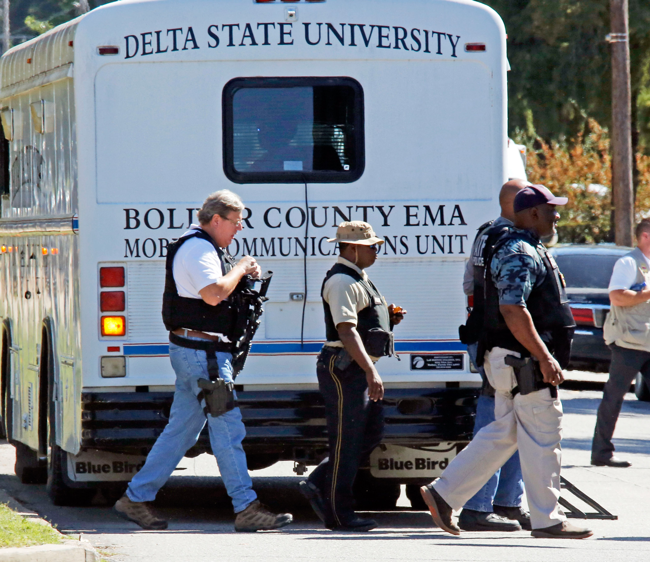 Law enforcement walk across the Delta State University campus to search for an active shooter in connection with a the shooting of history professor Ethan Schmidt in his office at Delta State University in Cleveland, Miss., Monday, Sept. 14, 2015. Law en
