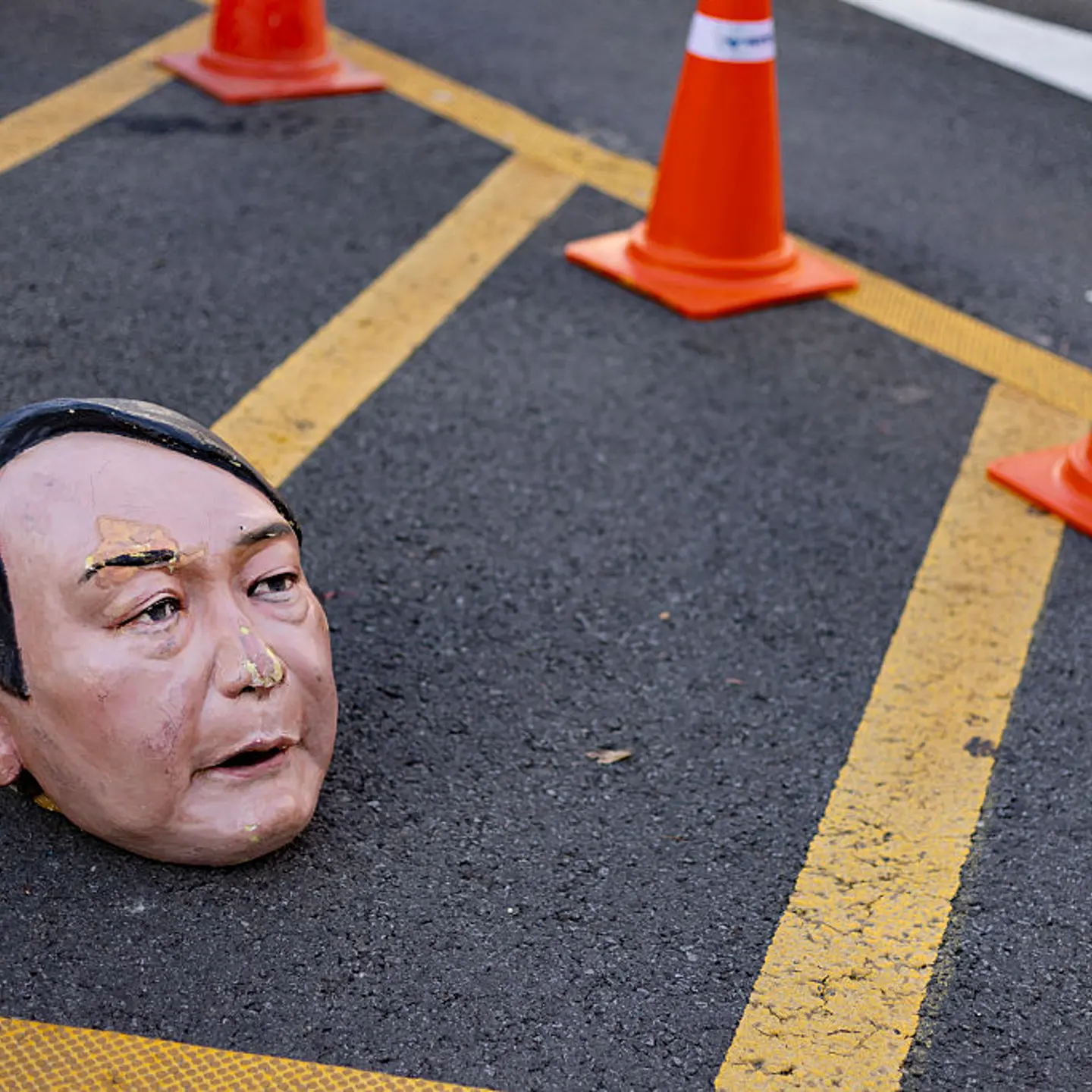 A mask of the impeached Yoon Suk-yeol, who faces trial on charges of illegal martial law and treason, lies on the street in front of the National Assembly in Yeouido, Seoul, South Korea, on Dec. 3, 2025.