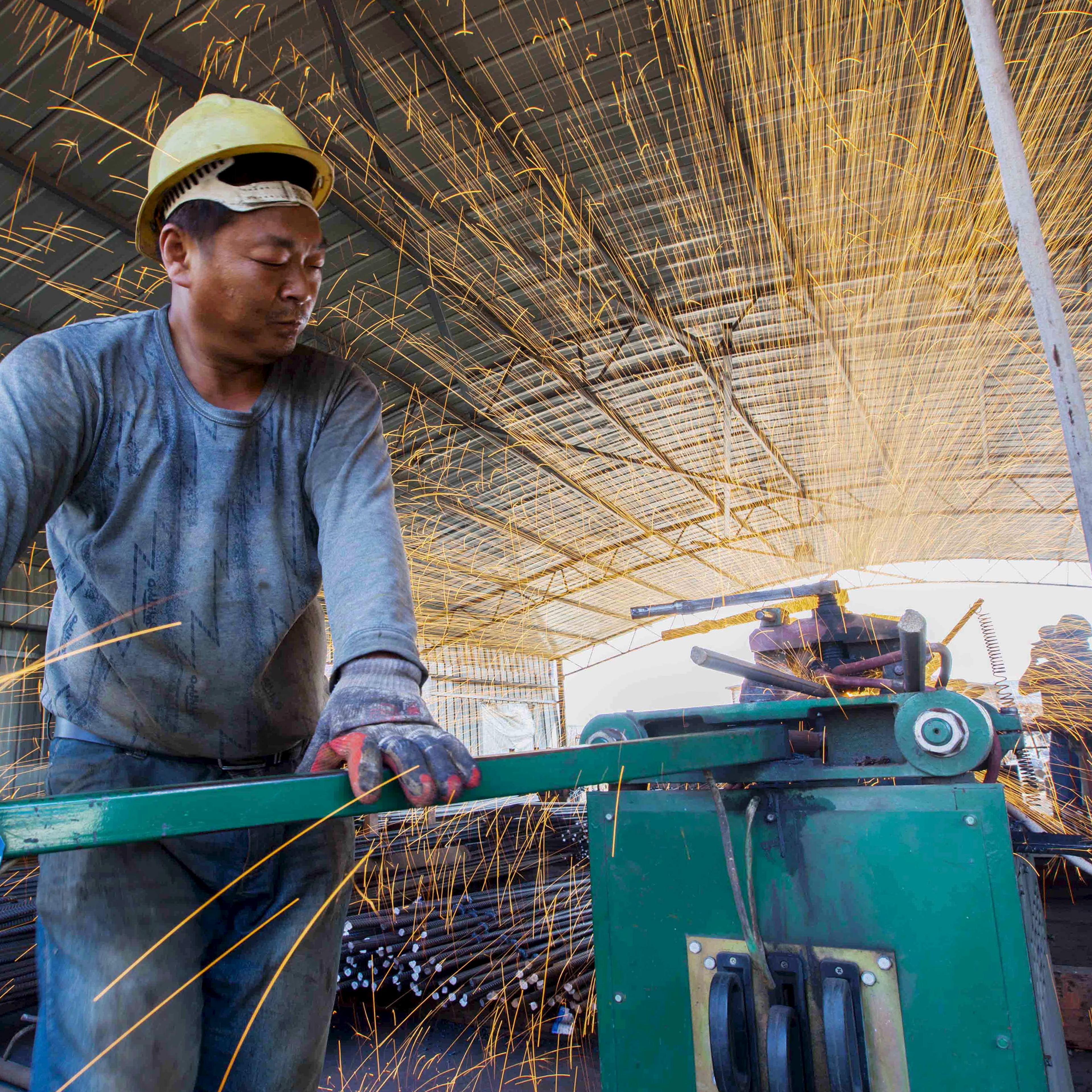 Labourer cuts steel bars at a railway bridge construction site in Lianyungang