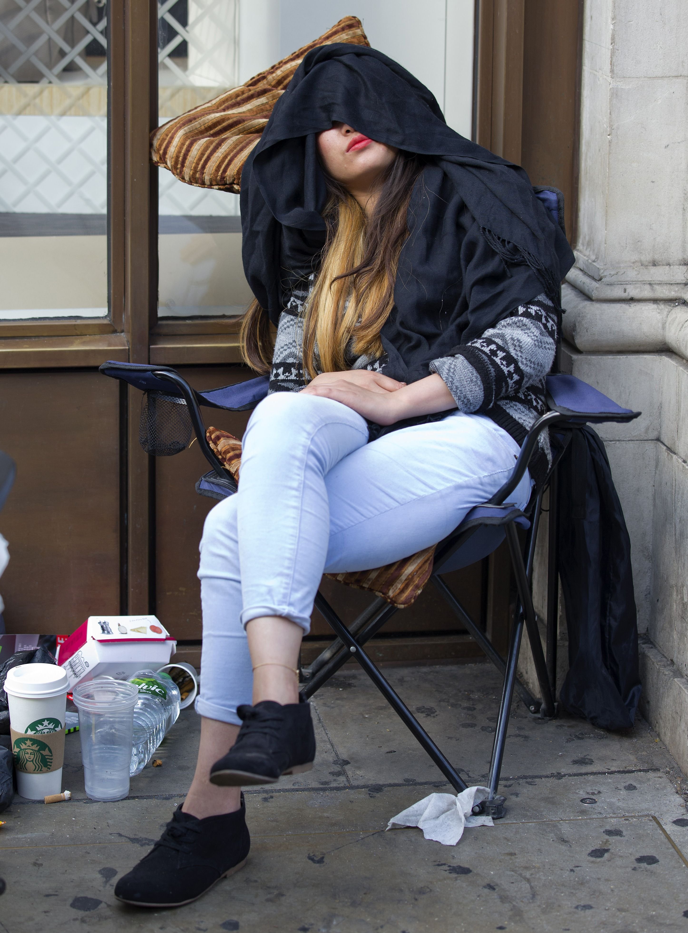 A woman sleeps in a chair as she waits in queue outside the Apple store in London on Sept. 18, 2014.