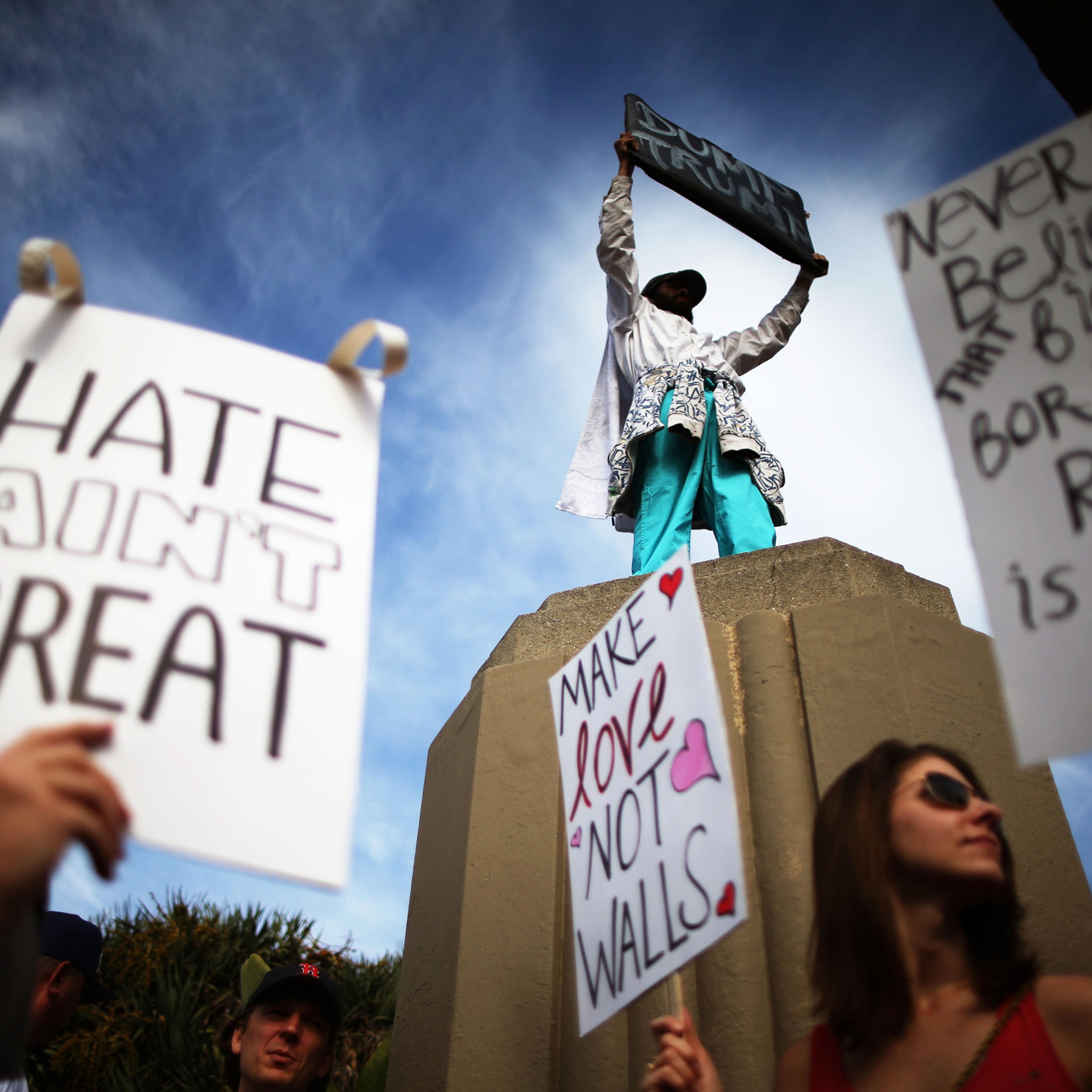 Protesters hold up signs during a march and rally against the election of Republican Donald Trump as President of the United States in Los Angeles, on Nov. 12, 2016.