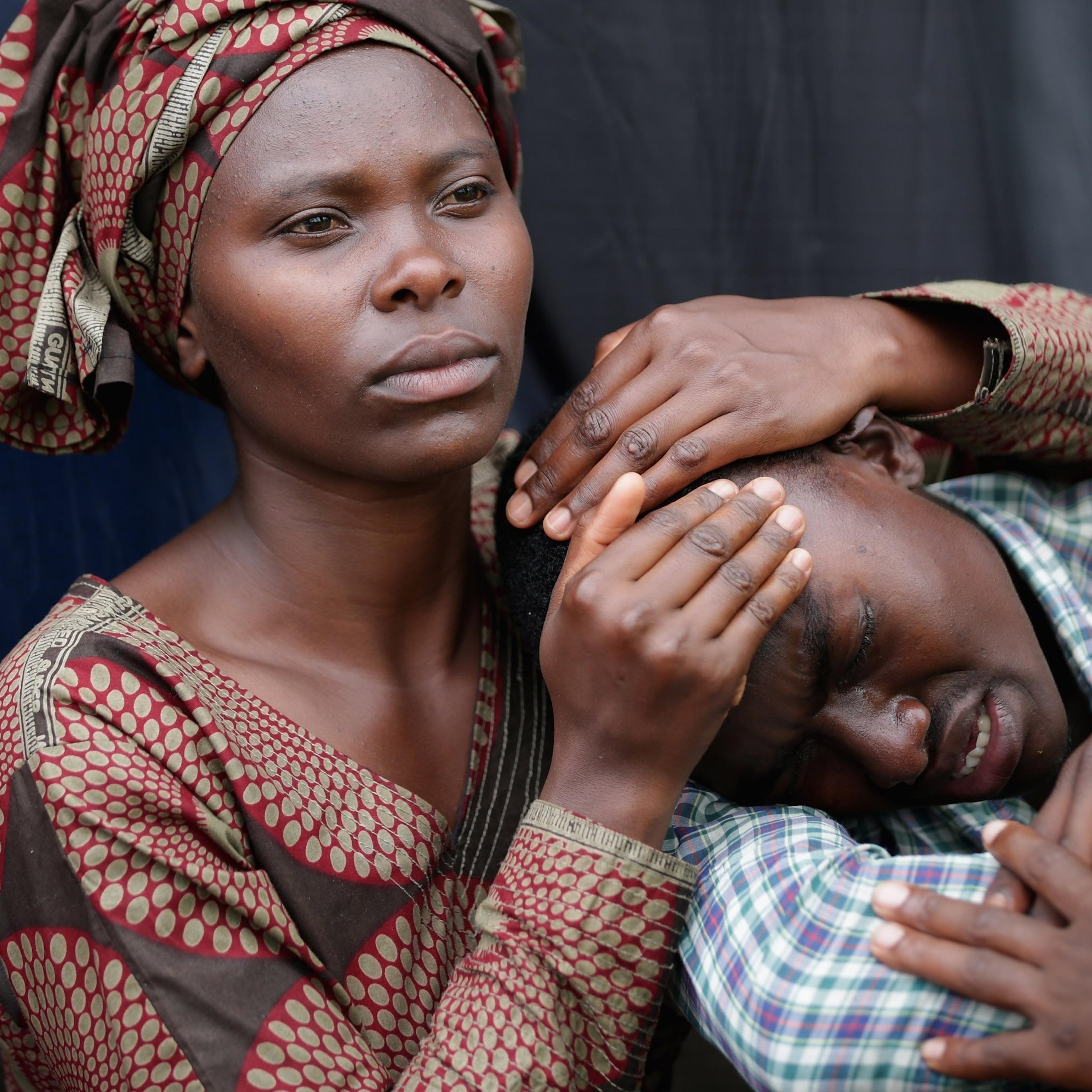 Rwandans impacted by the genocide comfort each other during a commemoration ceremony in Kigali on April 7