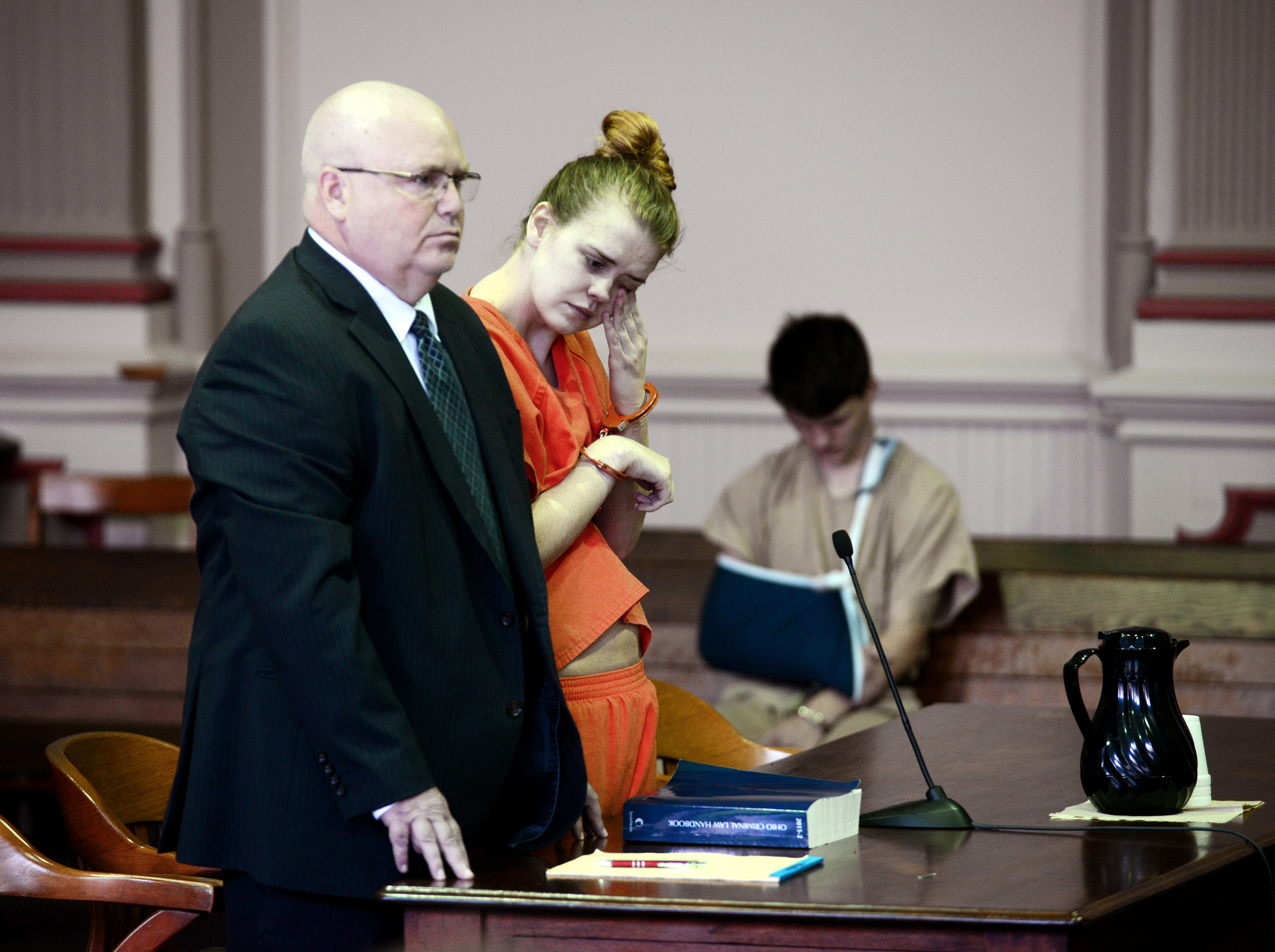 Emile Weaver, center, wipes her eyes while standing next to her attorney Aaron Miller, left, during her sentencing in Muskingum County Common Pleas Court in Zanesville, Ohio on June 27, 2016.