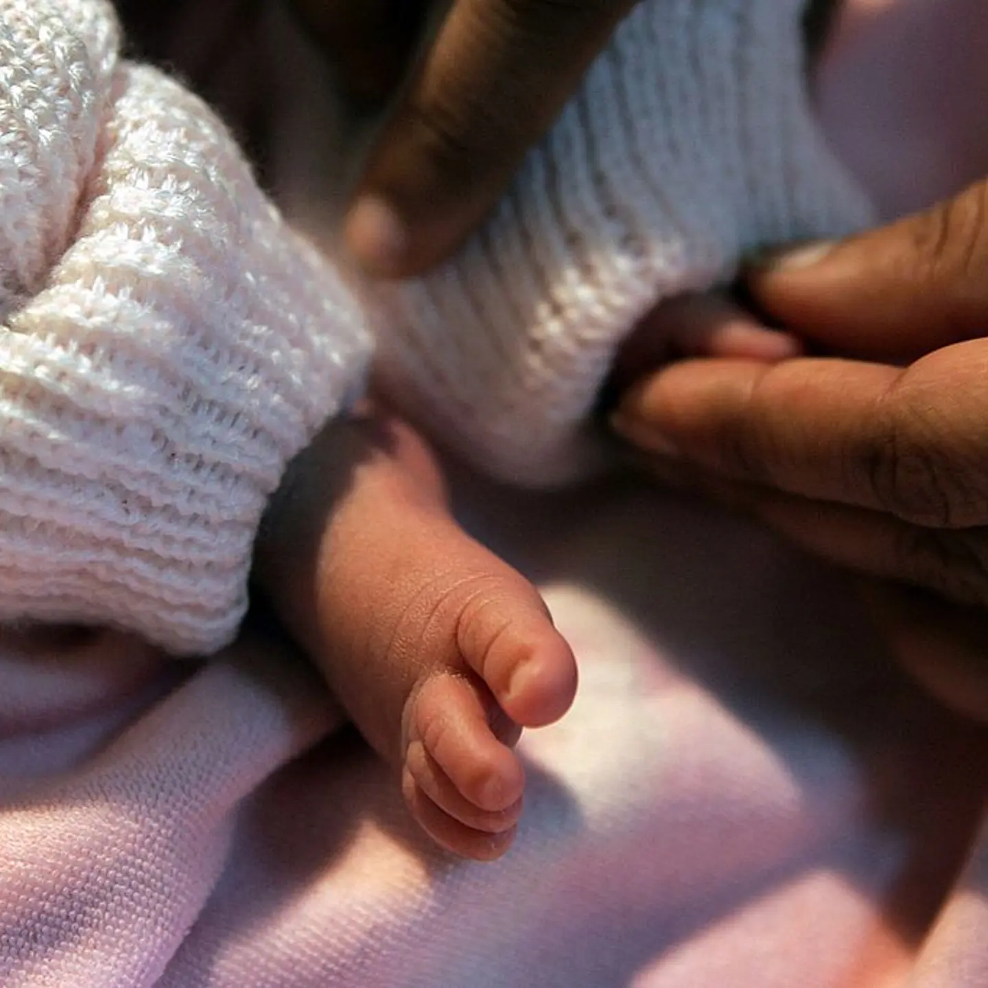 A newborn baby is checked by a nurse