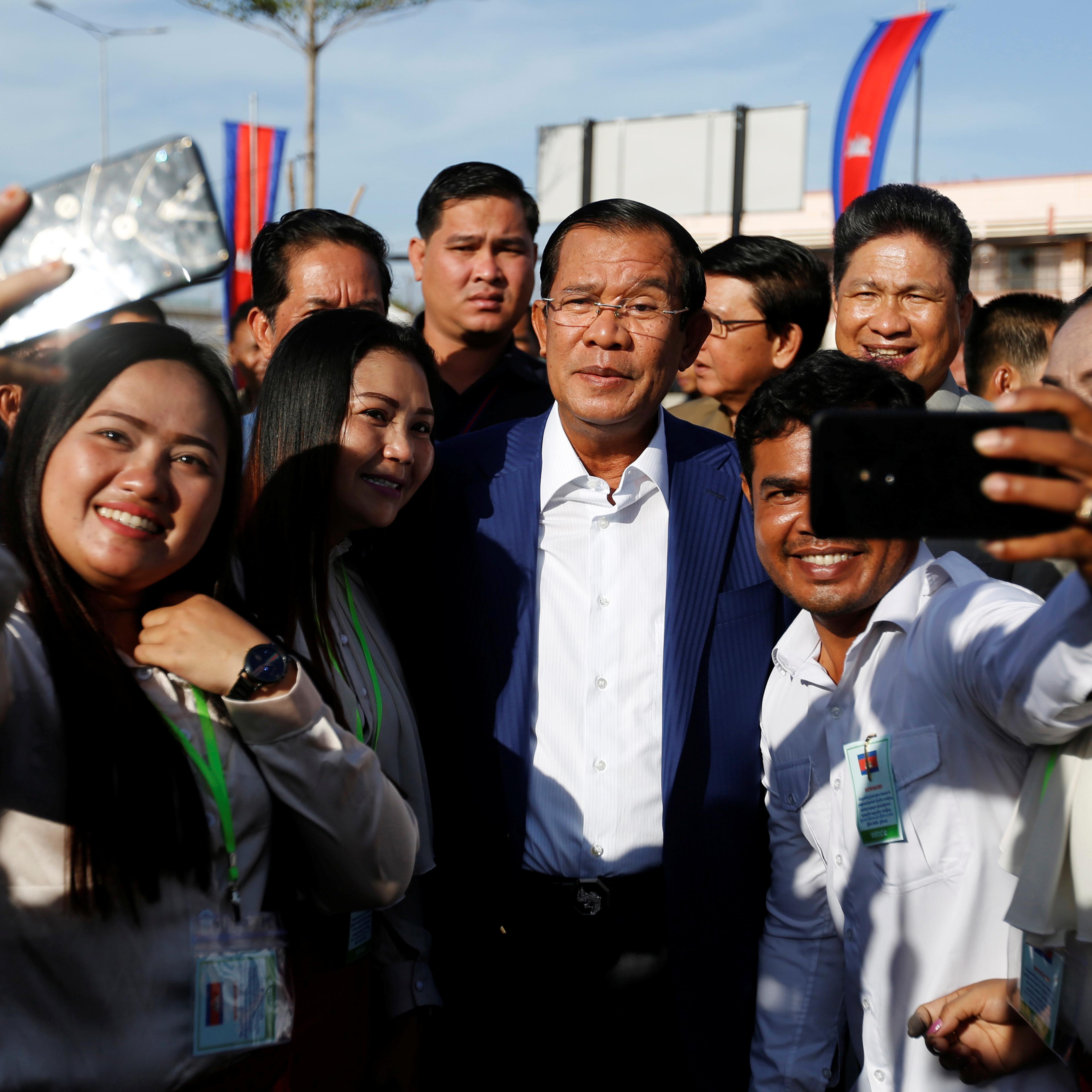 Supporters take pictures with Cambodia's Prime Minister Hun Sen as he attends an inauguration of a new boat terminal in Phnom Penh