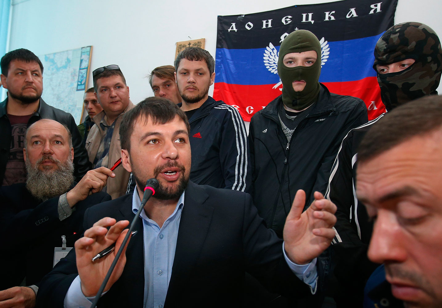 Denis Pushilin, foreground center, spokesman of the self-appointed Donetsk People’s Republic, speaks to reporters inside the regional administration building seized earlier in Donetsk, Ukraine, April 18, 2014.