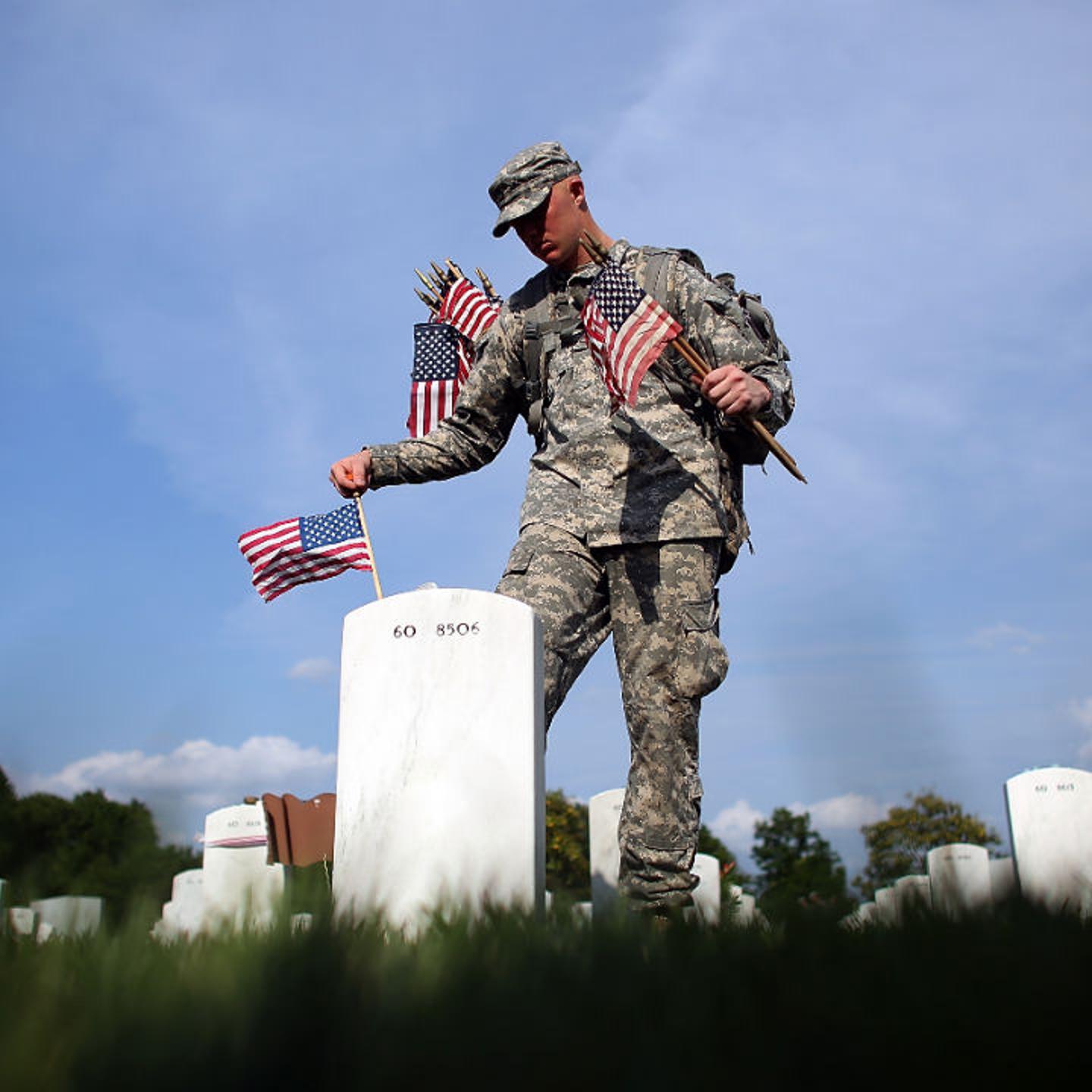 Members of the 3rd U.S. Infantry Regiment place American flags at the graves of U.S. soldiers