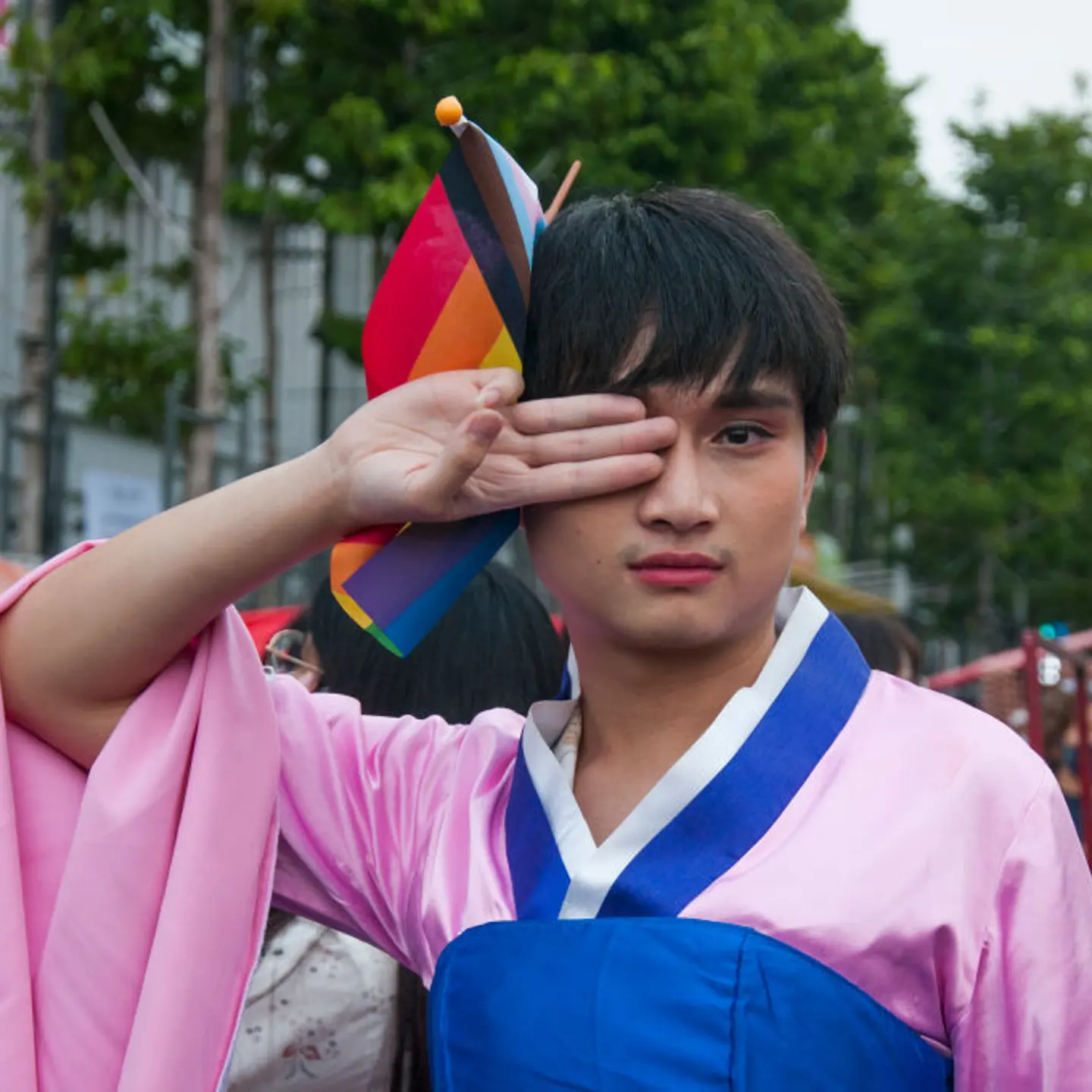 A protester wearing a Korean traditional dress makes three