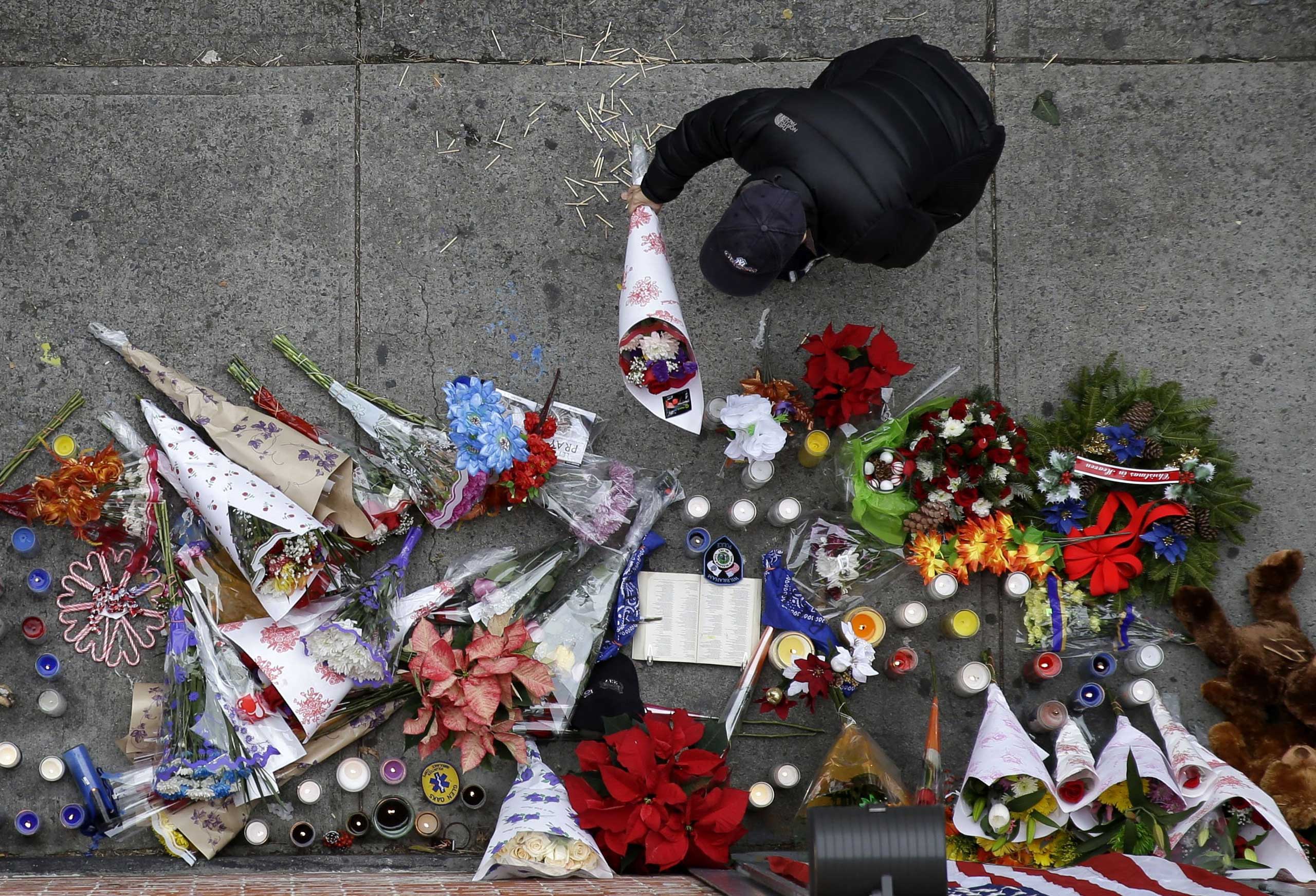 A man leaves flowers at an impromptu memorial near the site where two police officers were killed the day before in the Brooklyn borough of New York on Dec. 21, 2014.