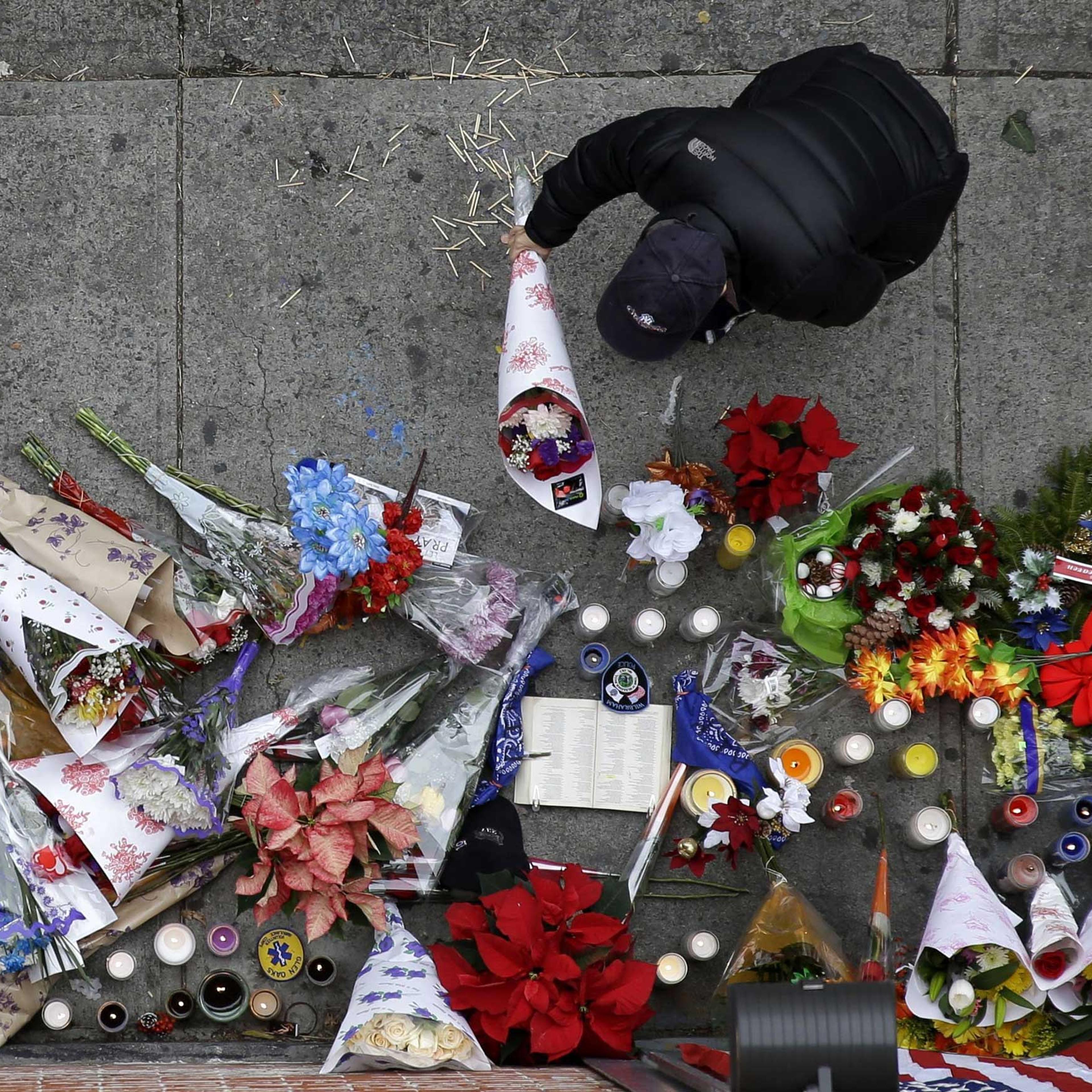 A man leaves flowers at an impromptu memorial near the site where two police officers were killed the day before in the Brooklyn borough of New York on Dec. 21, 2014.