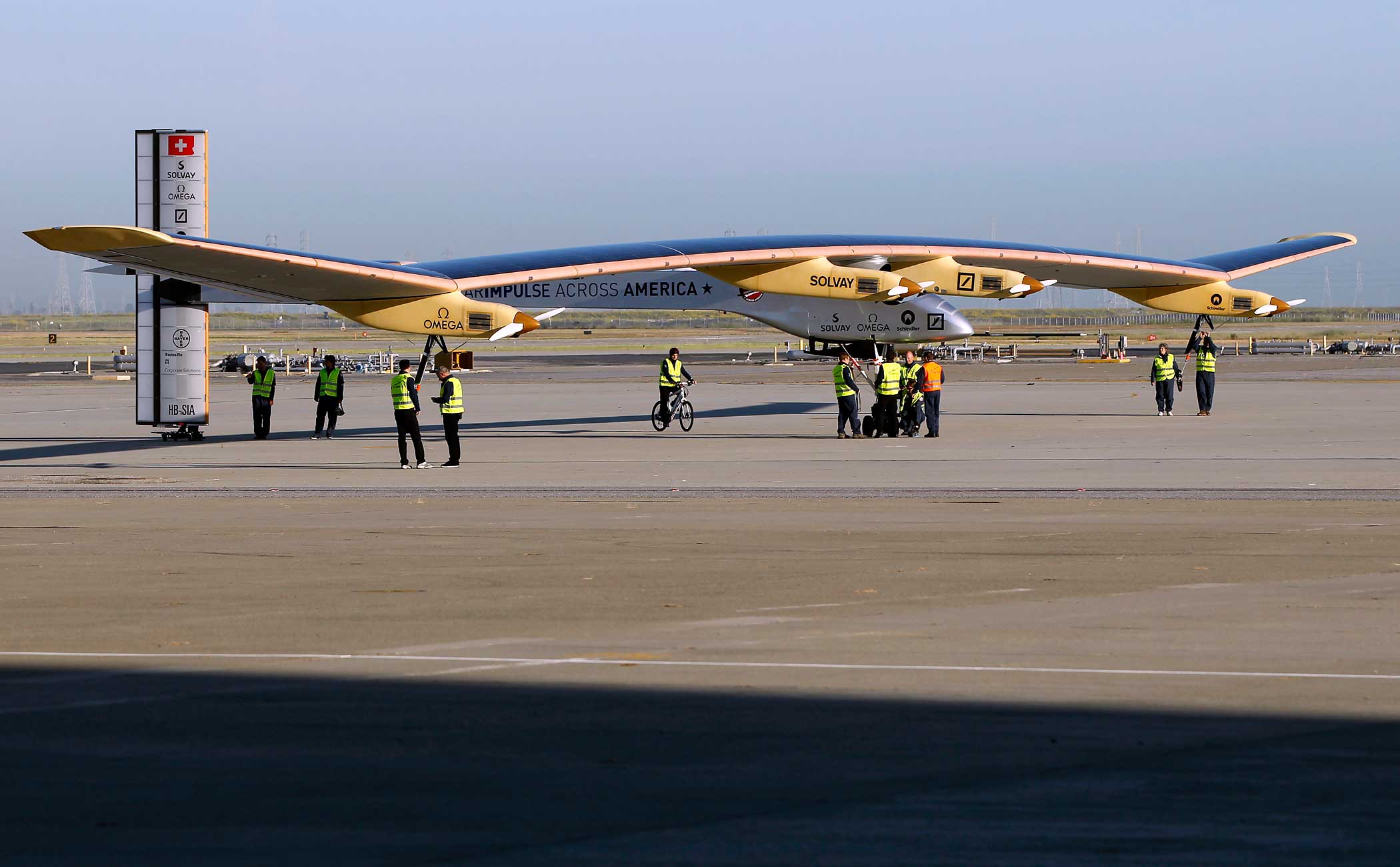 Crew members walk the Solar Impulse to its hangar following a test flight at Moffett Field in Mountain View, California