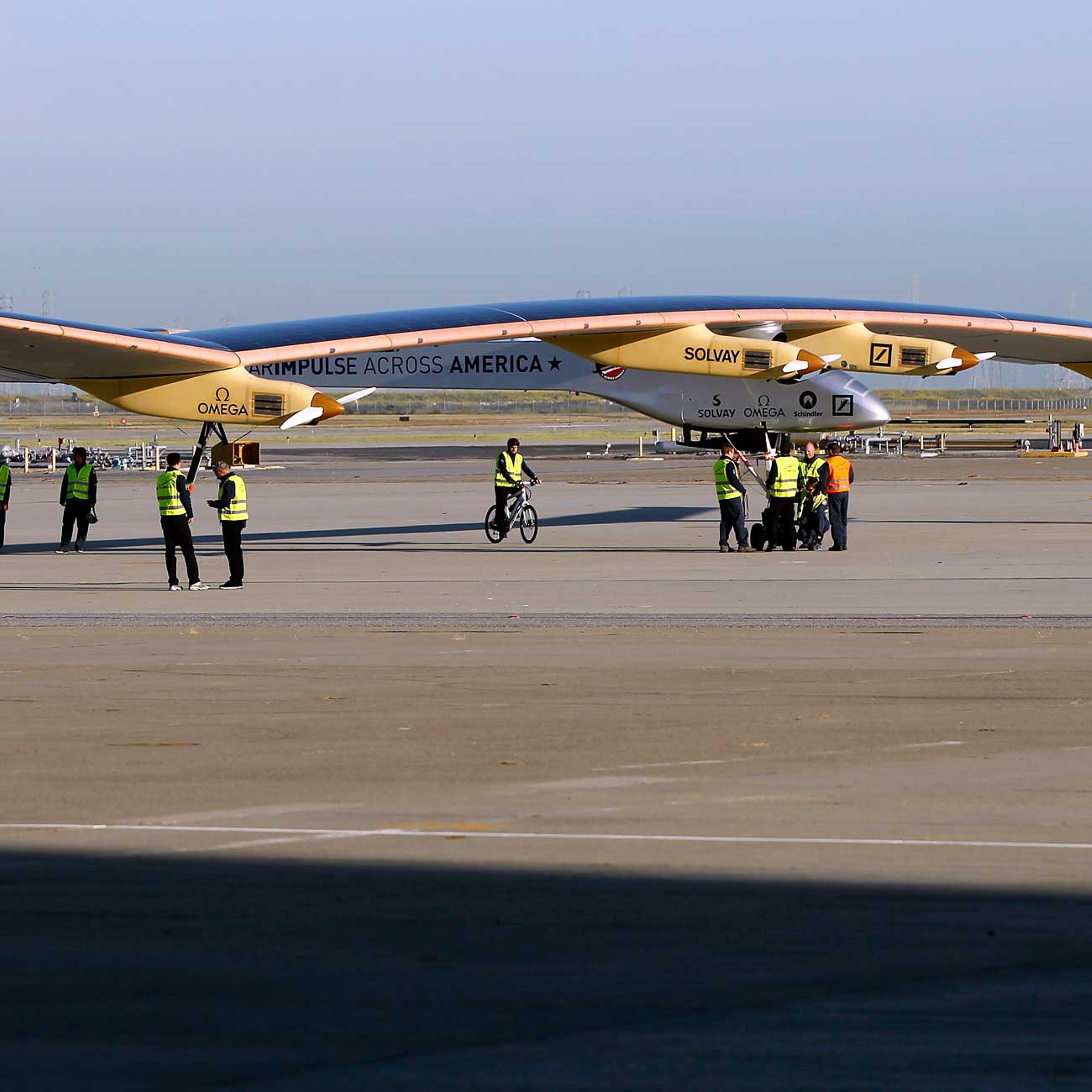 Crew members walk the Solar Impulse to its hangar following a test flight at Moffett Field in Mountain View, California