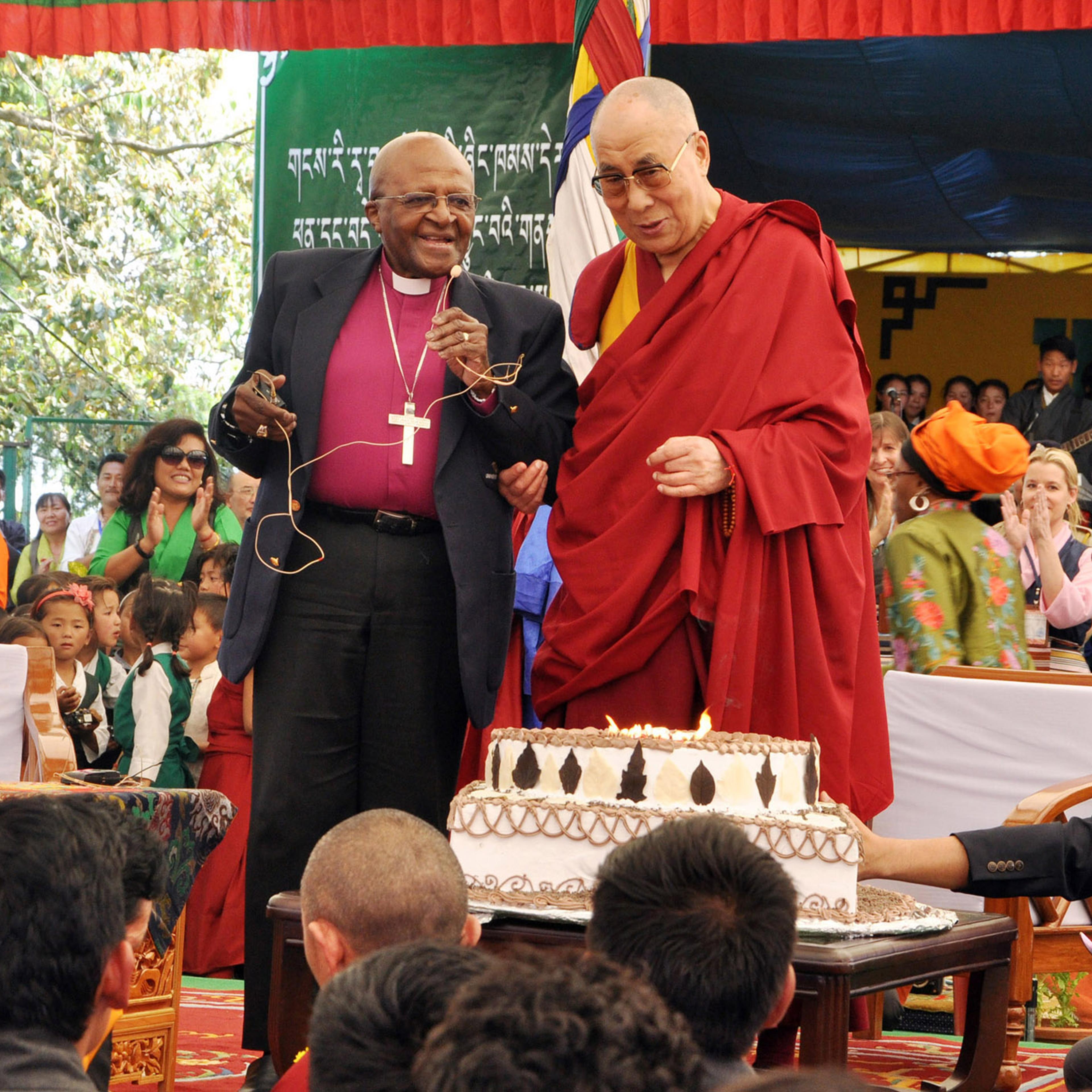 Spiritual leader Dalai Lama to blow out candles on his birthday cake as retired Archbishop Desmond Tutu looks on at the Tibetan Childrens Village School in Dharmsala, India, on April 23, 2015.