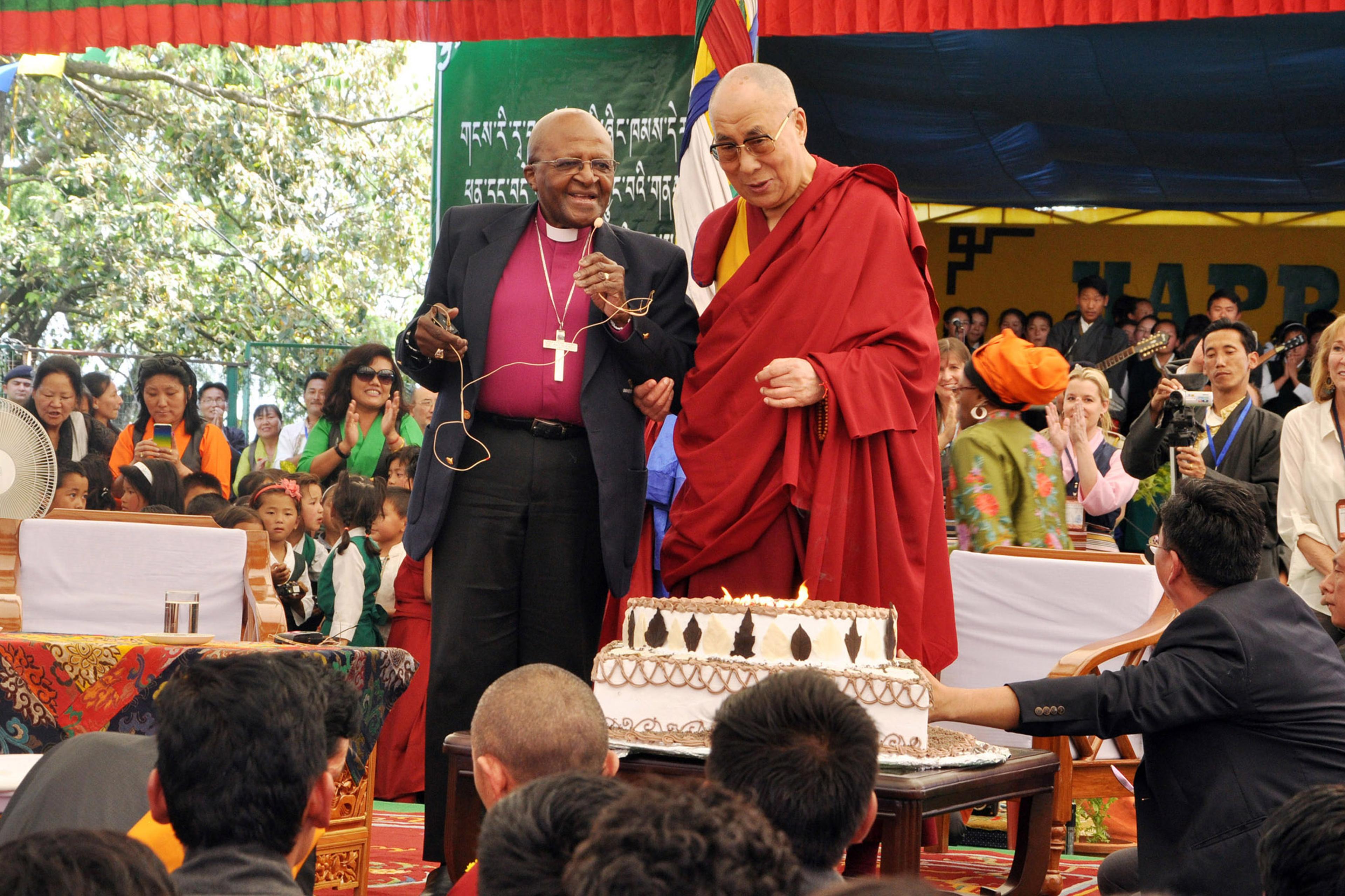 Spiritual leader Dalai Lama to blow out candles on his birthday cake as retired Archbishop Desmond Tutu looks on at the Tibetan Childrens Village School in Dharmsala, India, on April 23, 2015.
