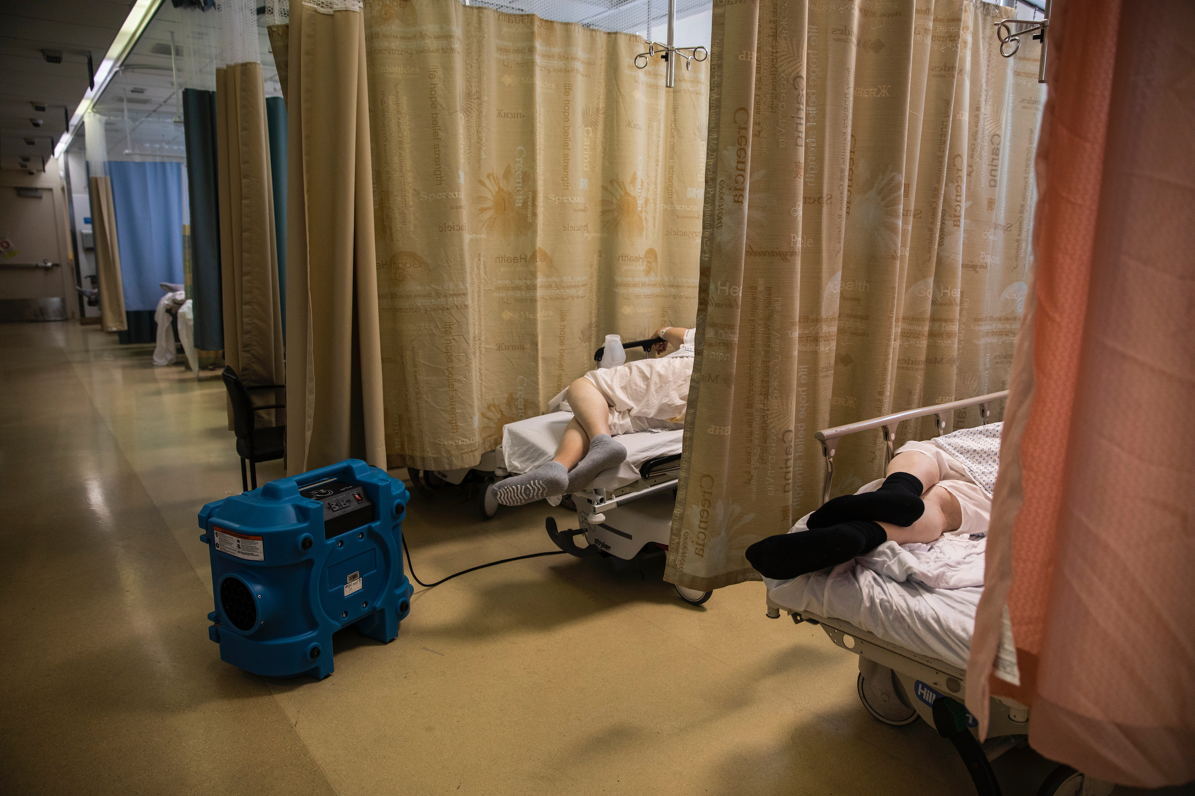 A COVID-19 patient rests with an air-purifying unit in the emergency room of Maimonides Medical Center in Brooklyn on March 26, 2020.
