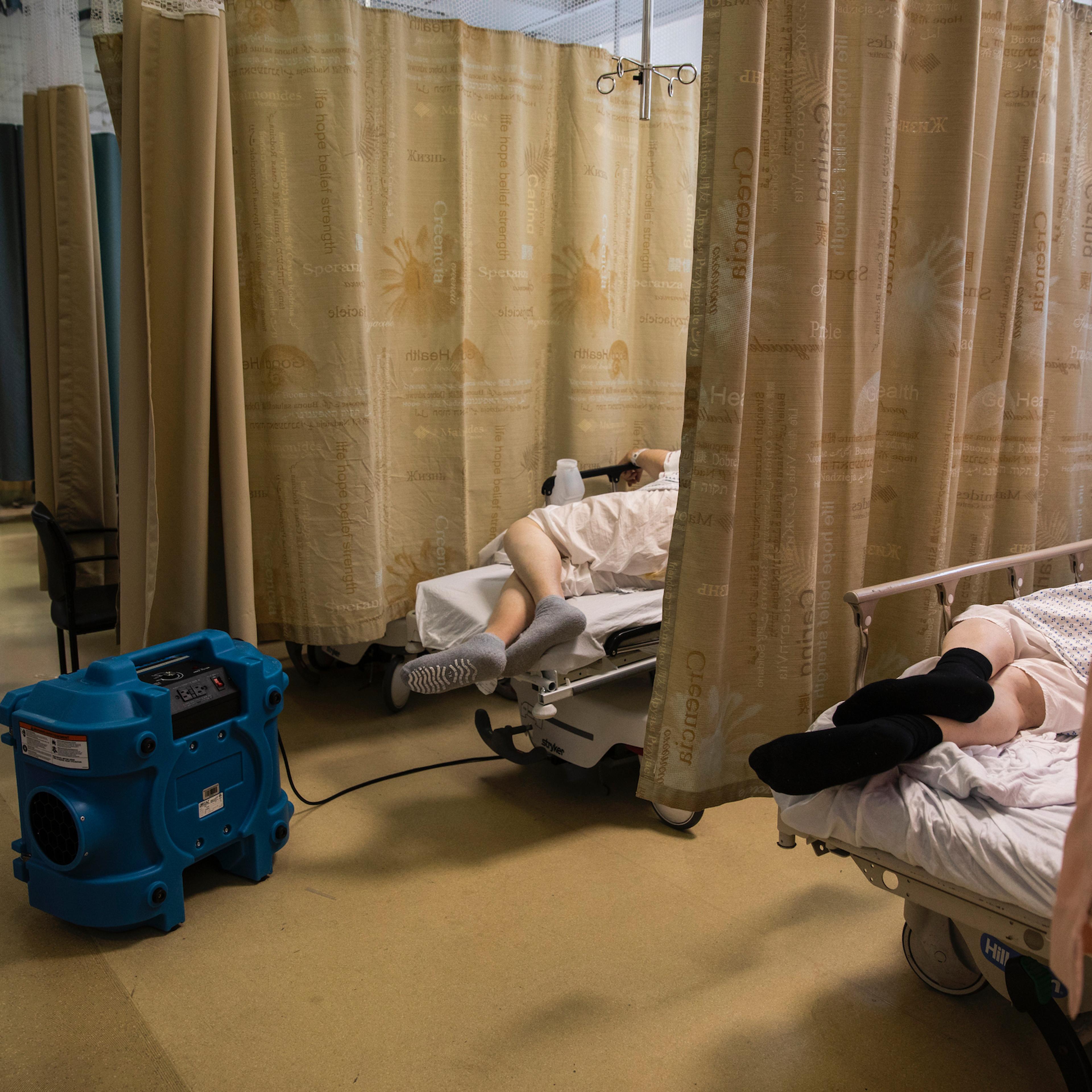 A COVID-19 patient rests with an air-purifying unit in the emergency room of Maimonides Medical Center in Brooklyn on March 26, 2020.
