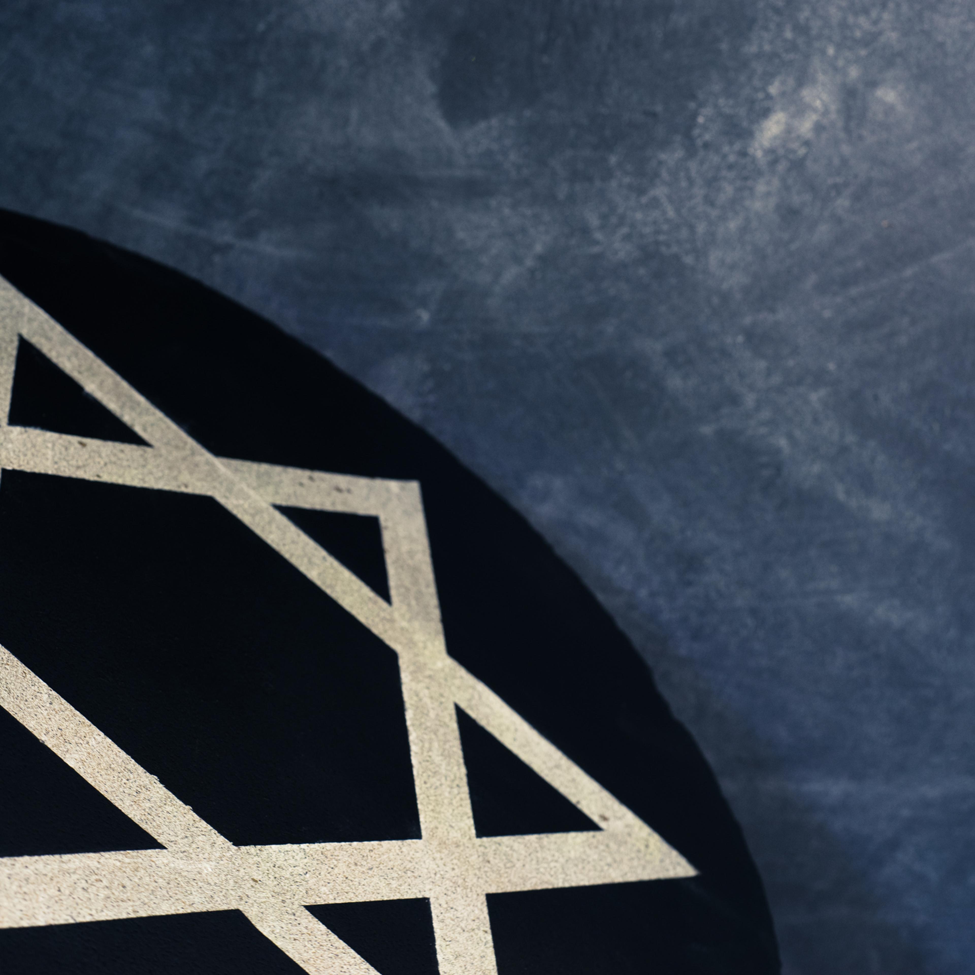 White Star of David on a black stone round.