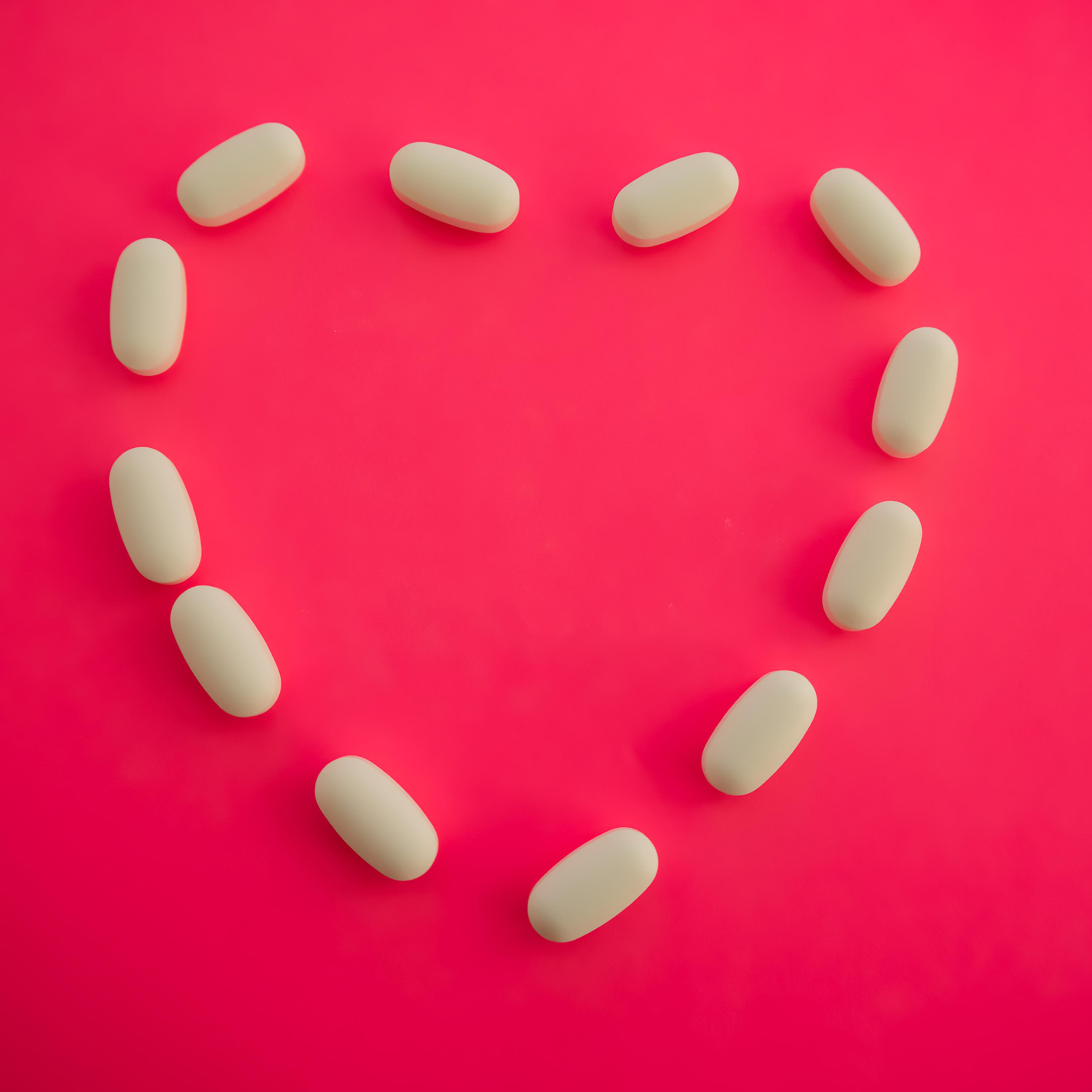 medicinal white prescription pills in shape of heart