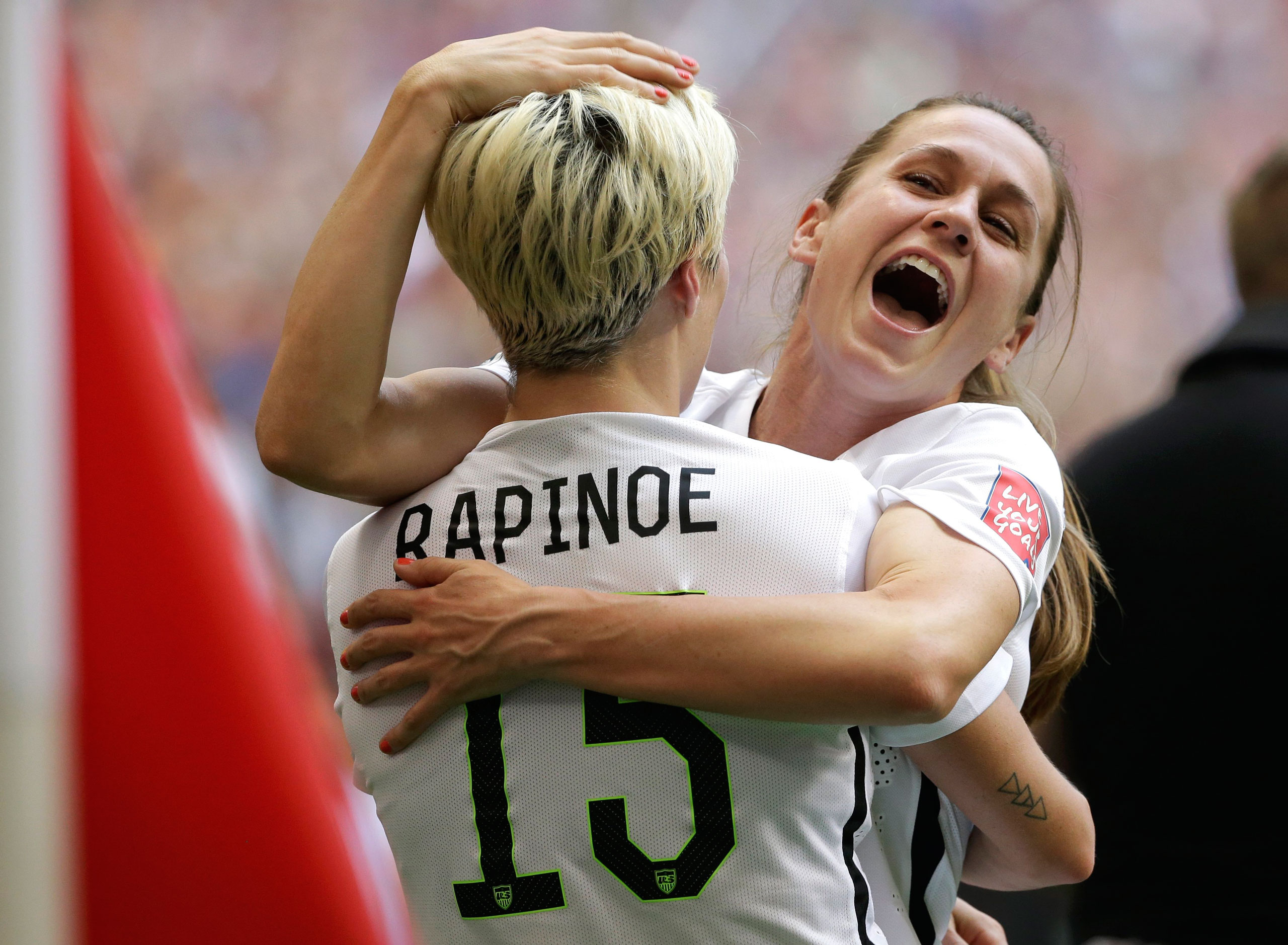 United States' Heather O'Reilly, right, hugs Megan Rapinoe (15) after the U.S. beat Japan 5-2 in the FIFA Women's World Cup soccer championship in Vancouver, British Columbia, Canada, Sunday, July 5, 2015. (AP Photo/Elaine Thompson)