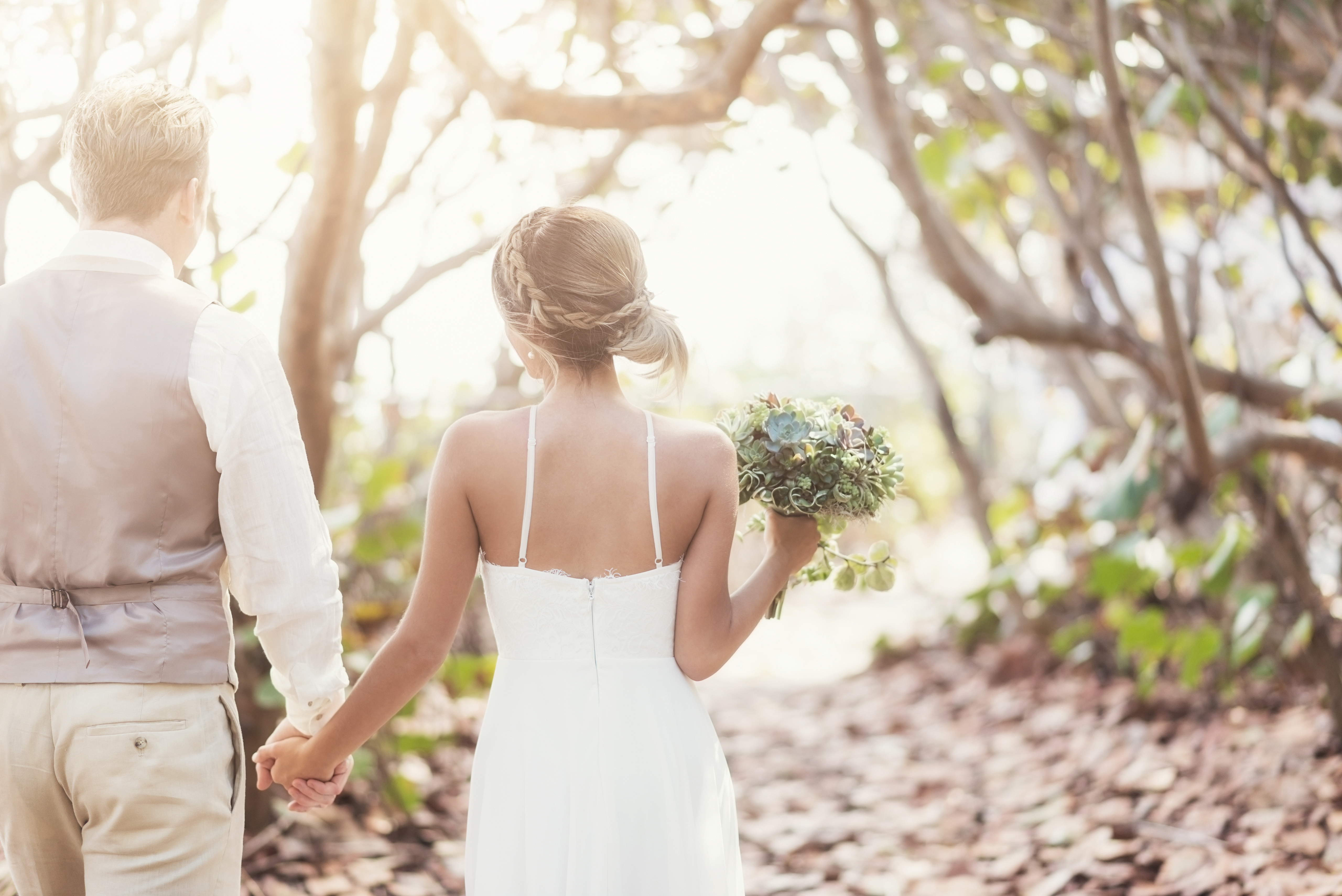 Bride and groom holding hands outdoors
